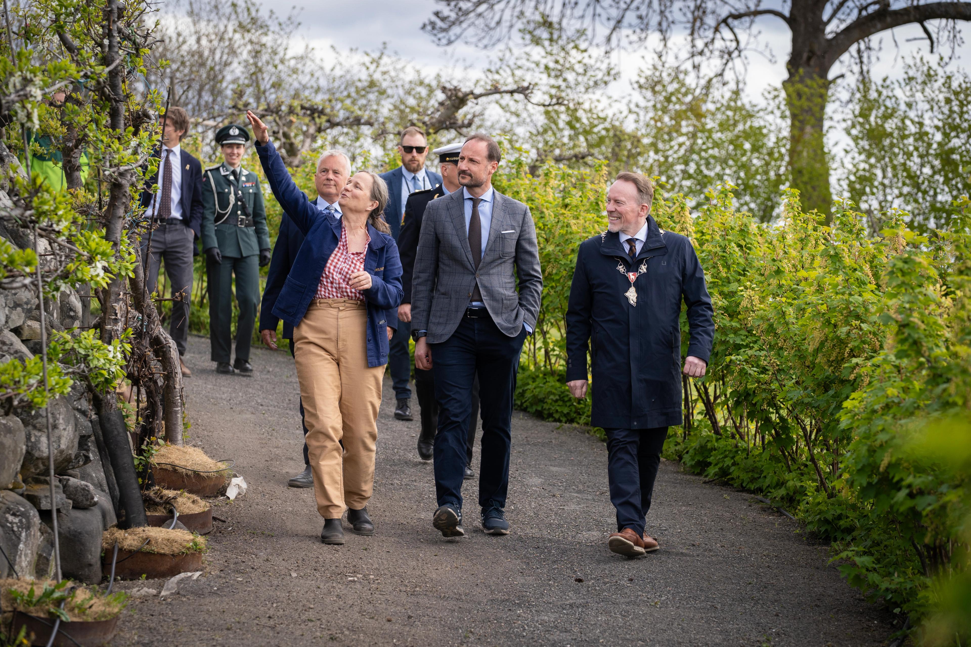 Marianne Olssøn peker mens hun går nedover en bred sti.