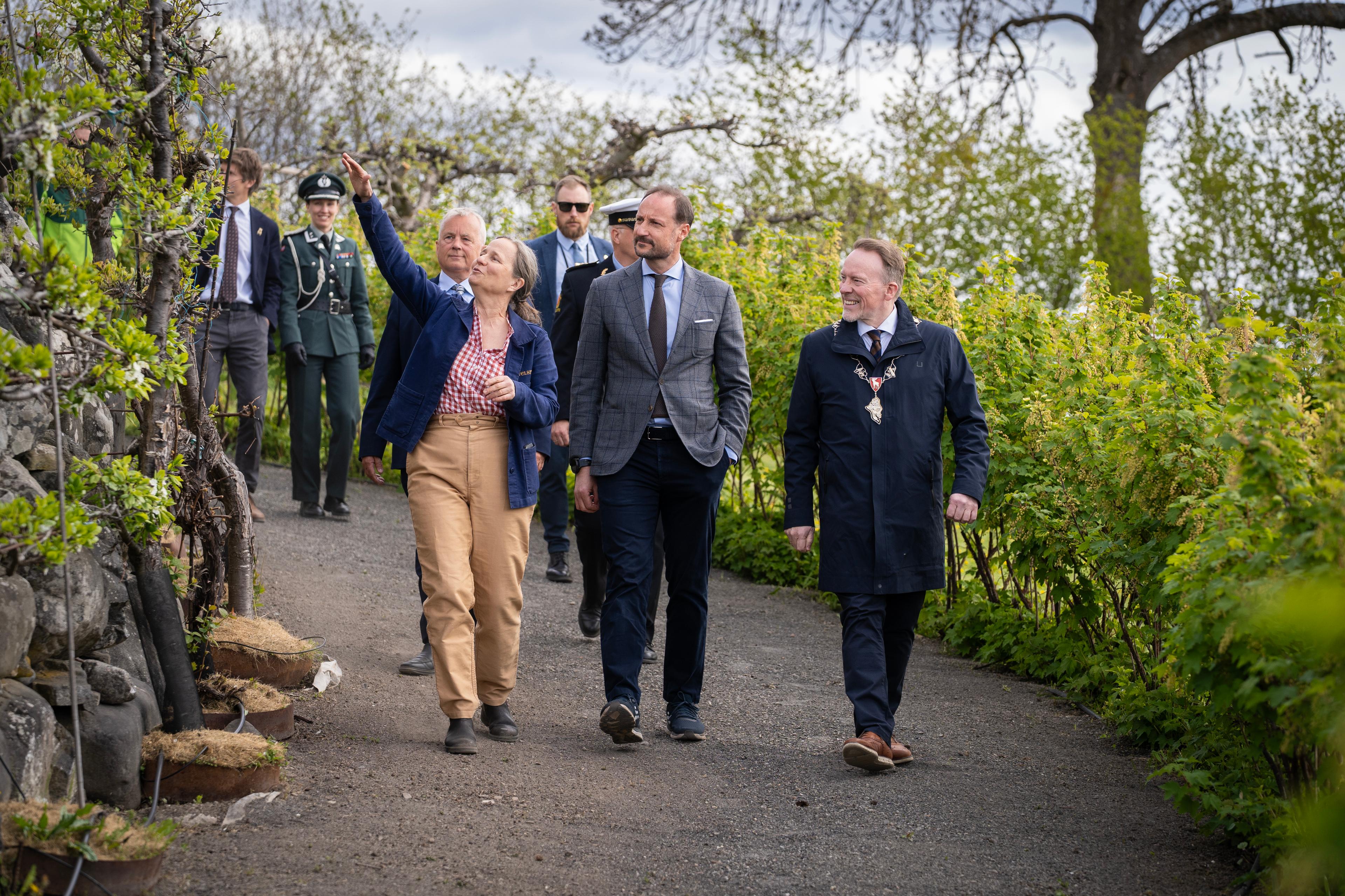 Marianne Olssøn peker mens hun går nedover en bred sti.