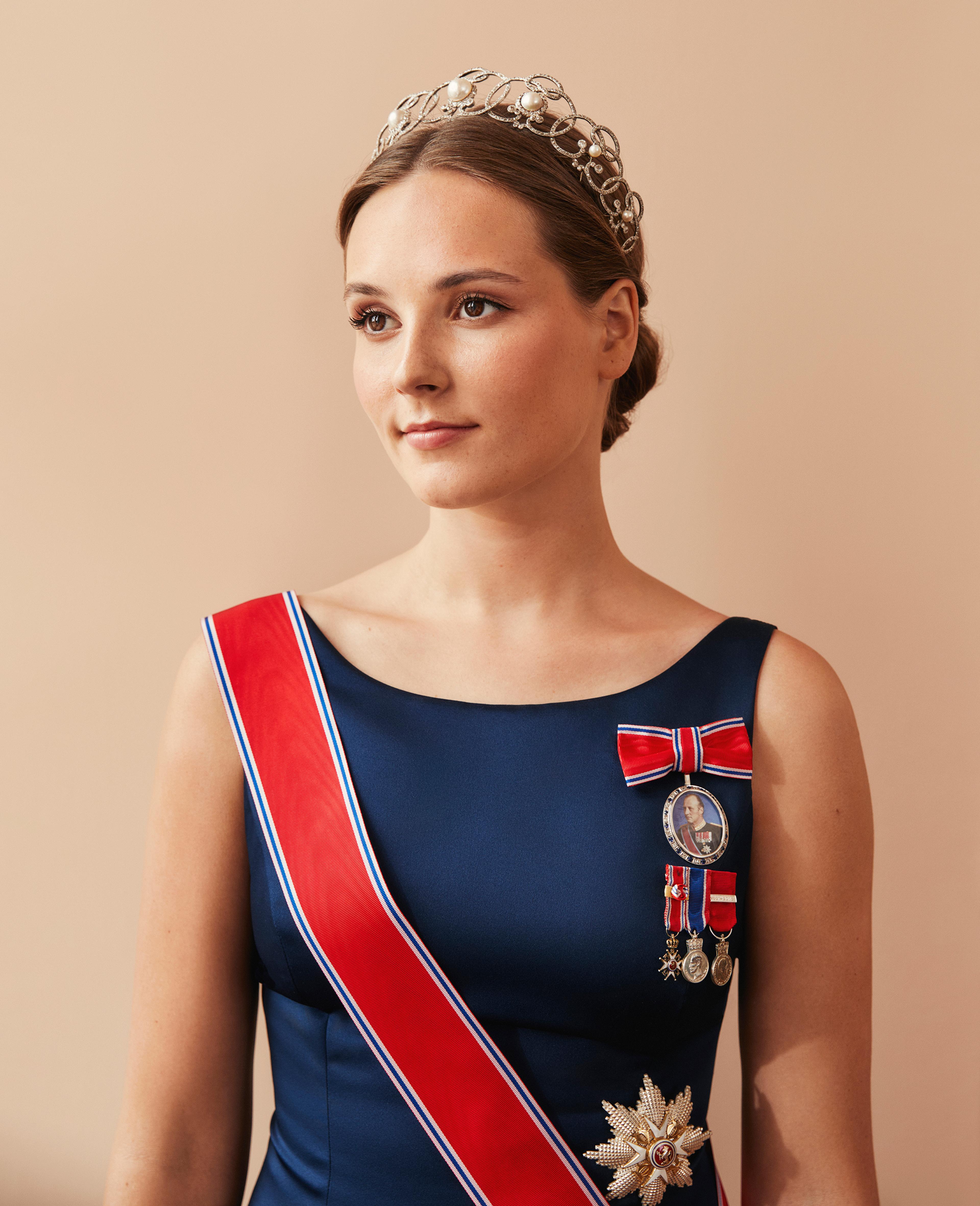 Prinsessen i halvfigur med dypblå kjole, ordener og tiara.
