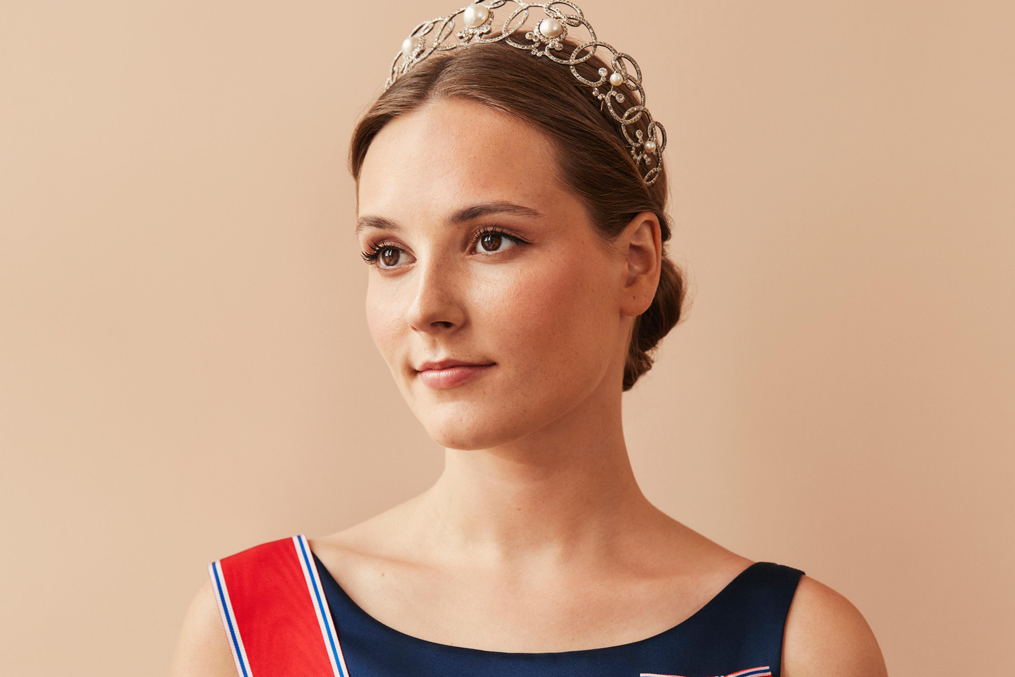 Prinsessen i halvfigur med dypblå kjole, ordener og tiara.