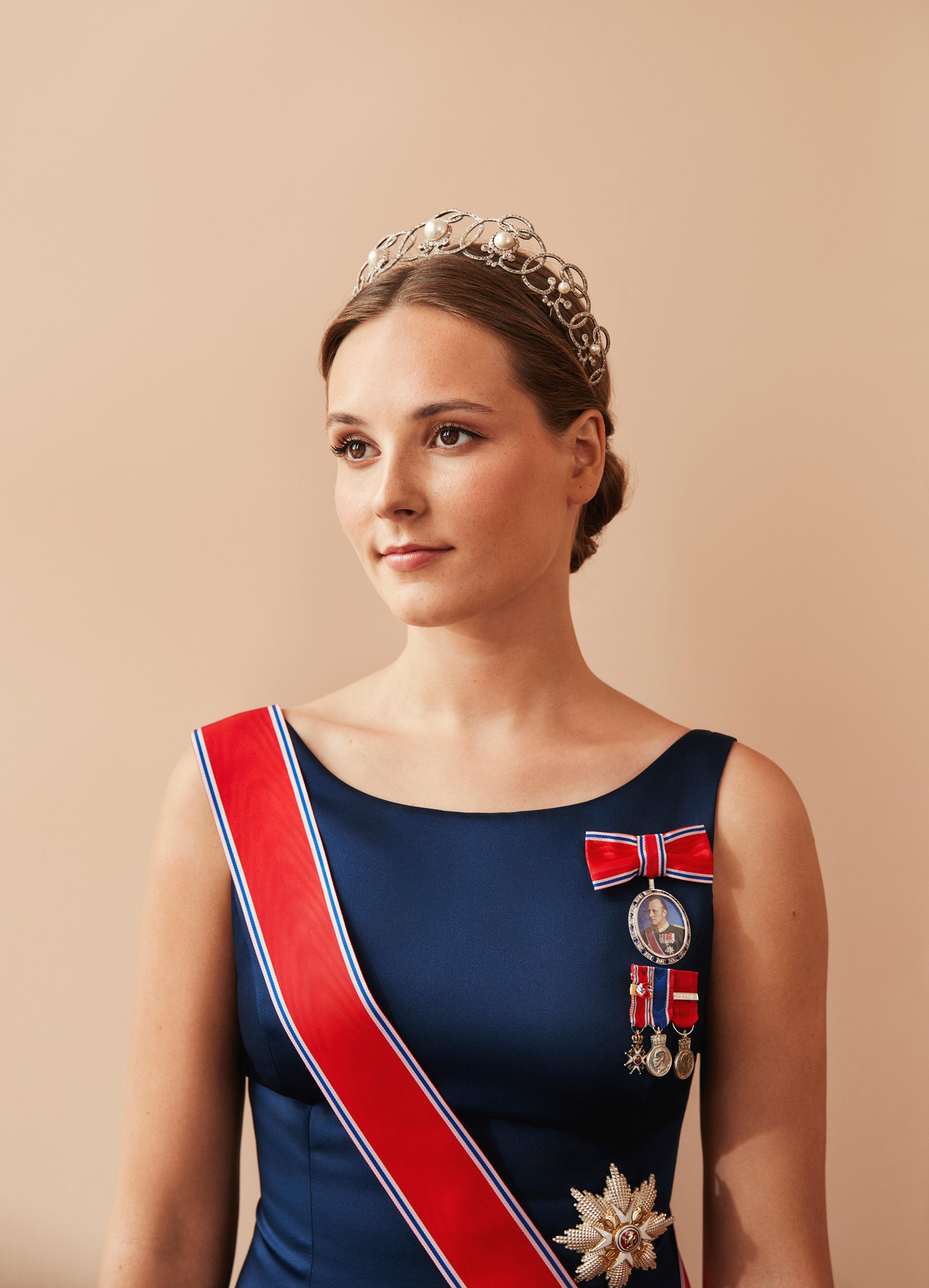 Prinsessen i halvfigur med dypblå kjole, ordener og tiara.