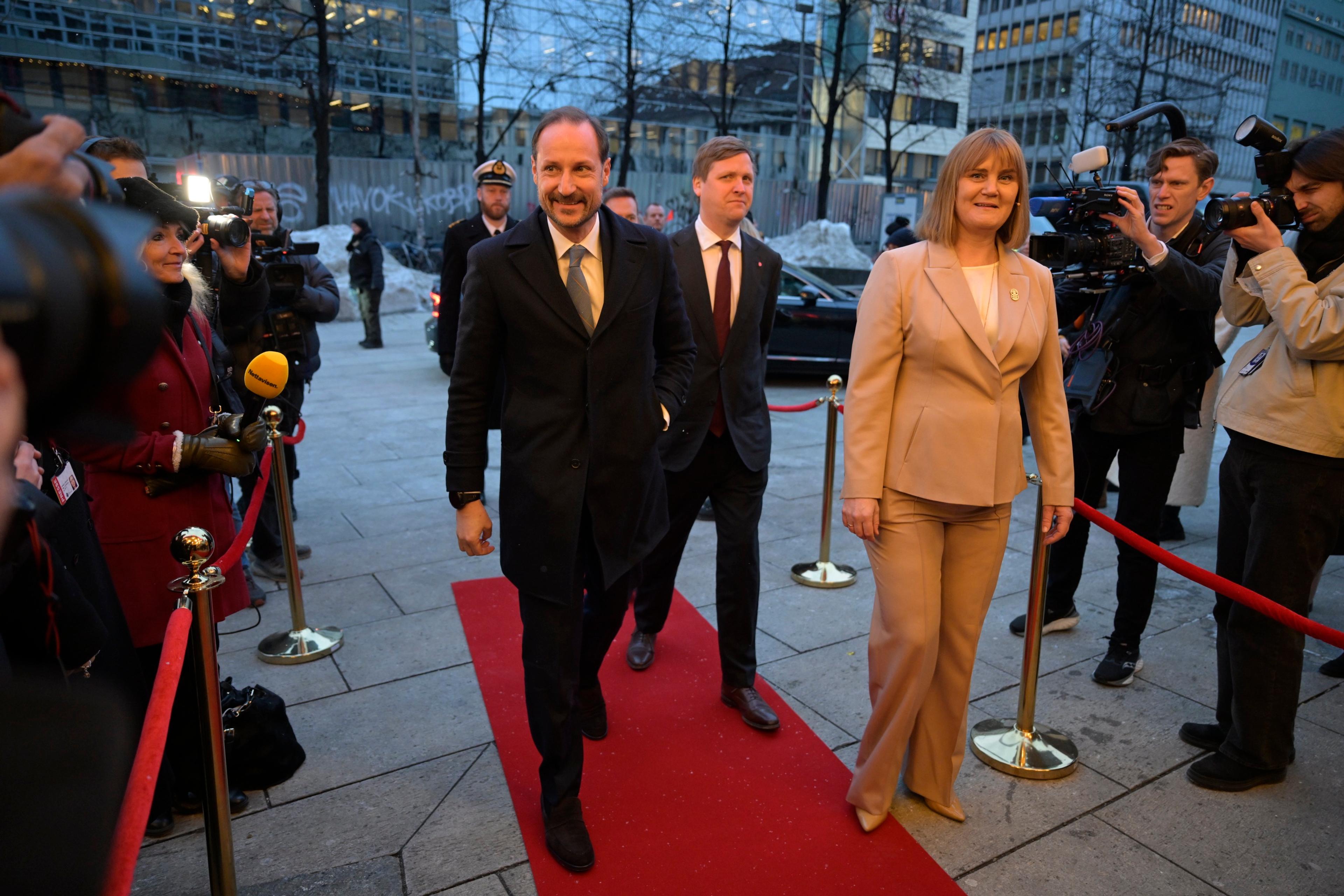 Nynorsk versjon Kronprinsen går på den raude løparen saman med Gunn Jorid og Åsmund Aukrust. På kvar side står presse med kamera og mikrofonar.