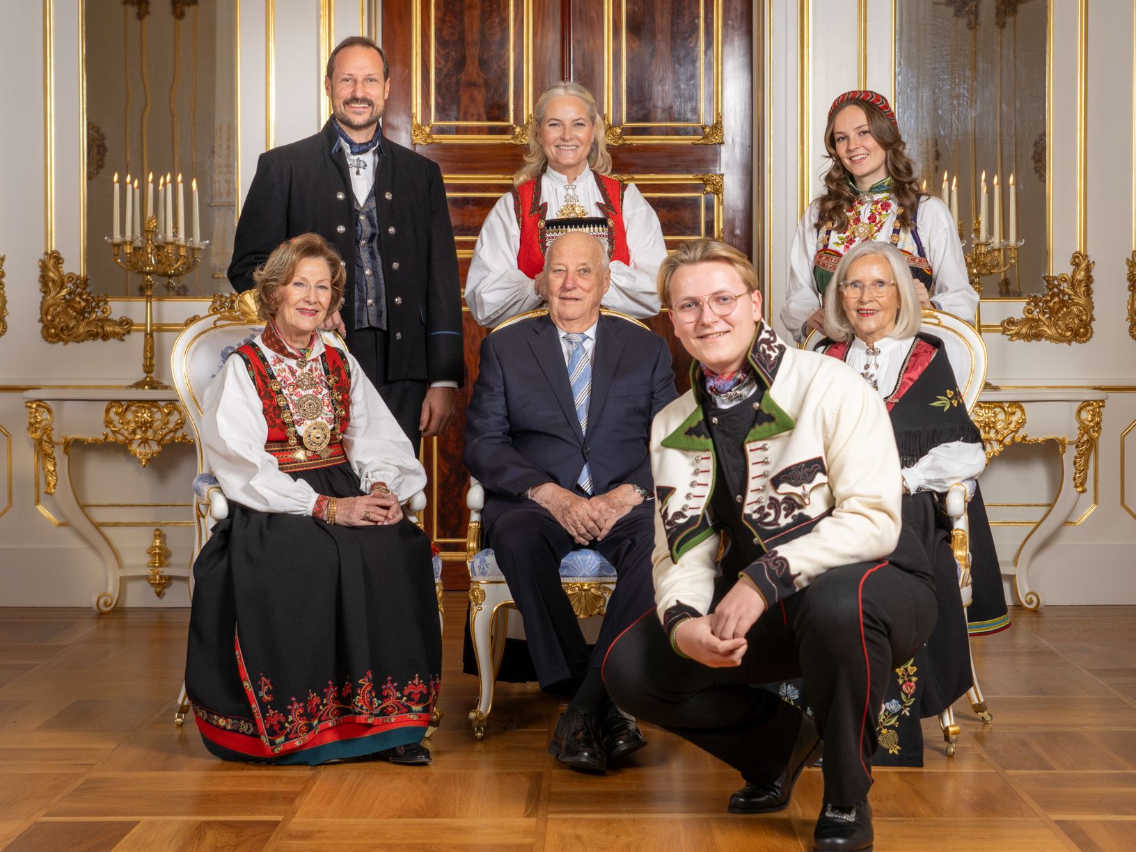 Prins Sverre Magnus i bunad, på huk foran Kongeparet, Kronprinsparet, sin søster og mormor. Alle i bunad eller dress.