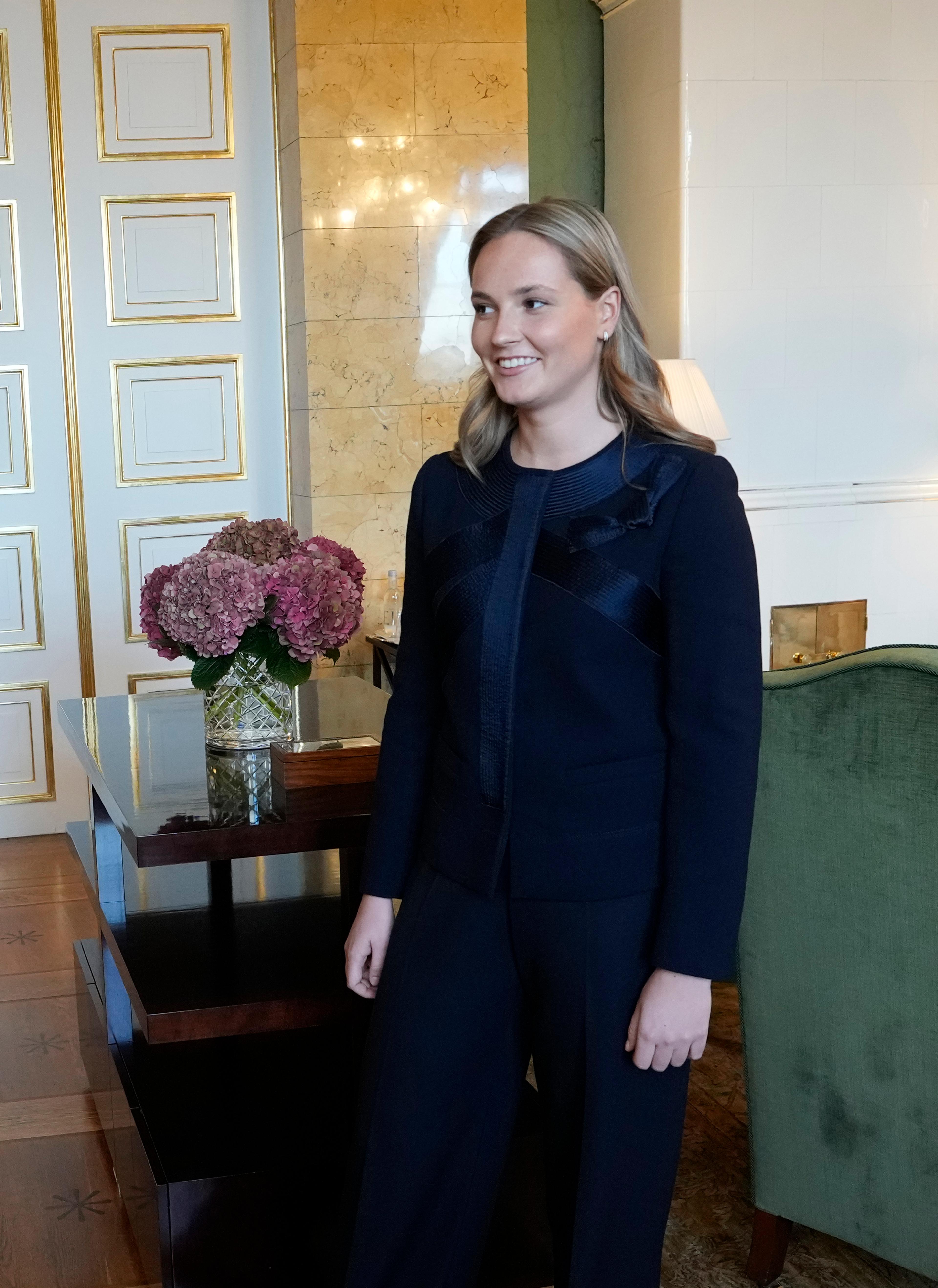 Kronprinsessen står smilende i værelset, som preges av hvitt og grønt.
