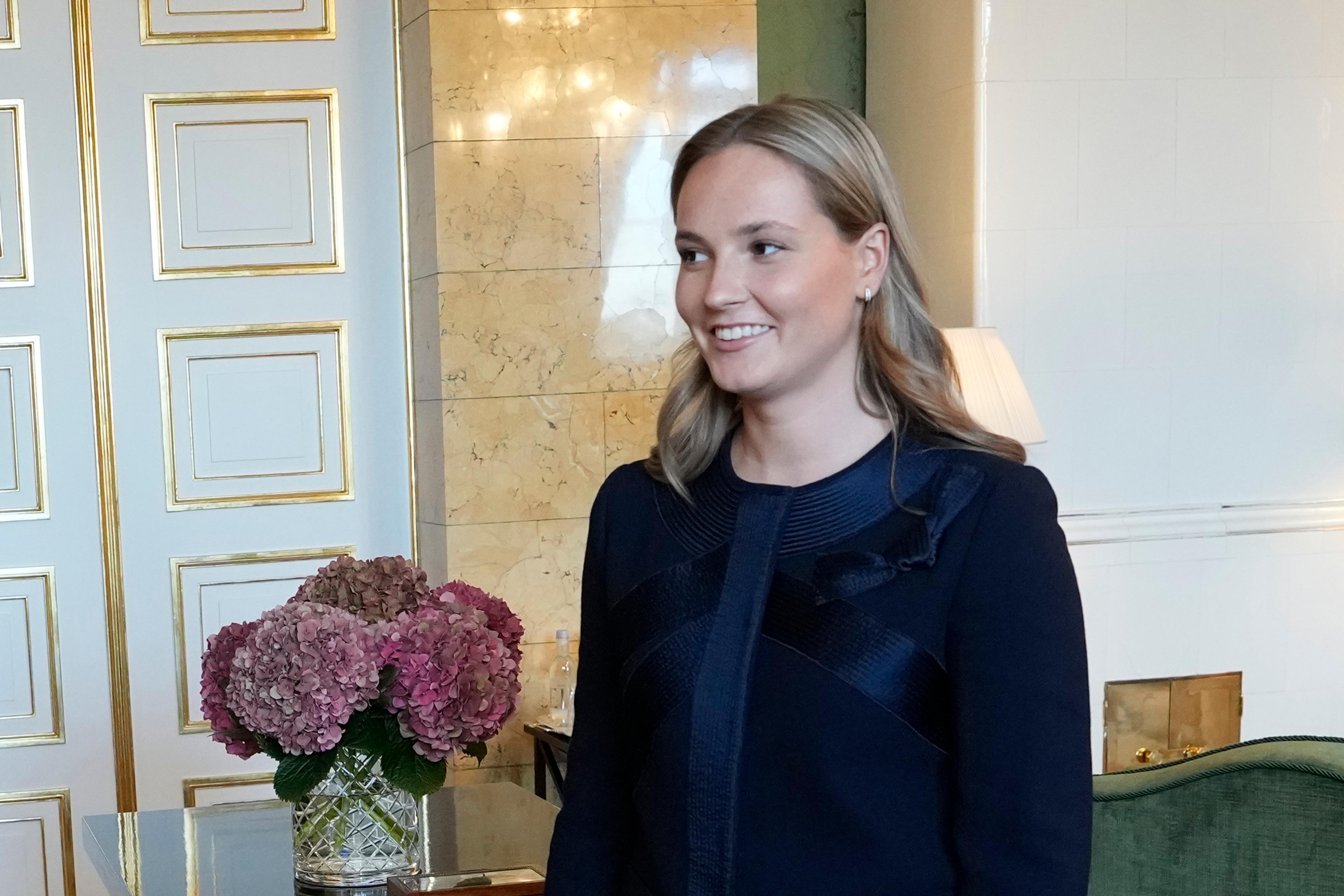 Kronprinsessen står smilende i værelset, som preges av hvitt og grønt.