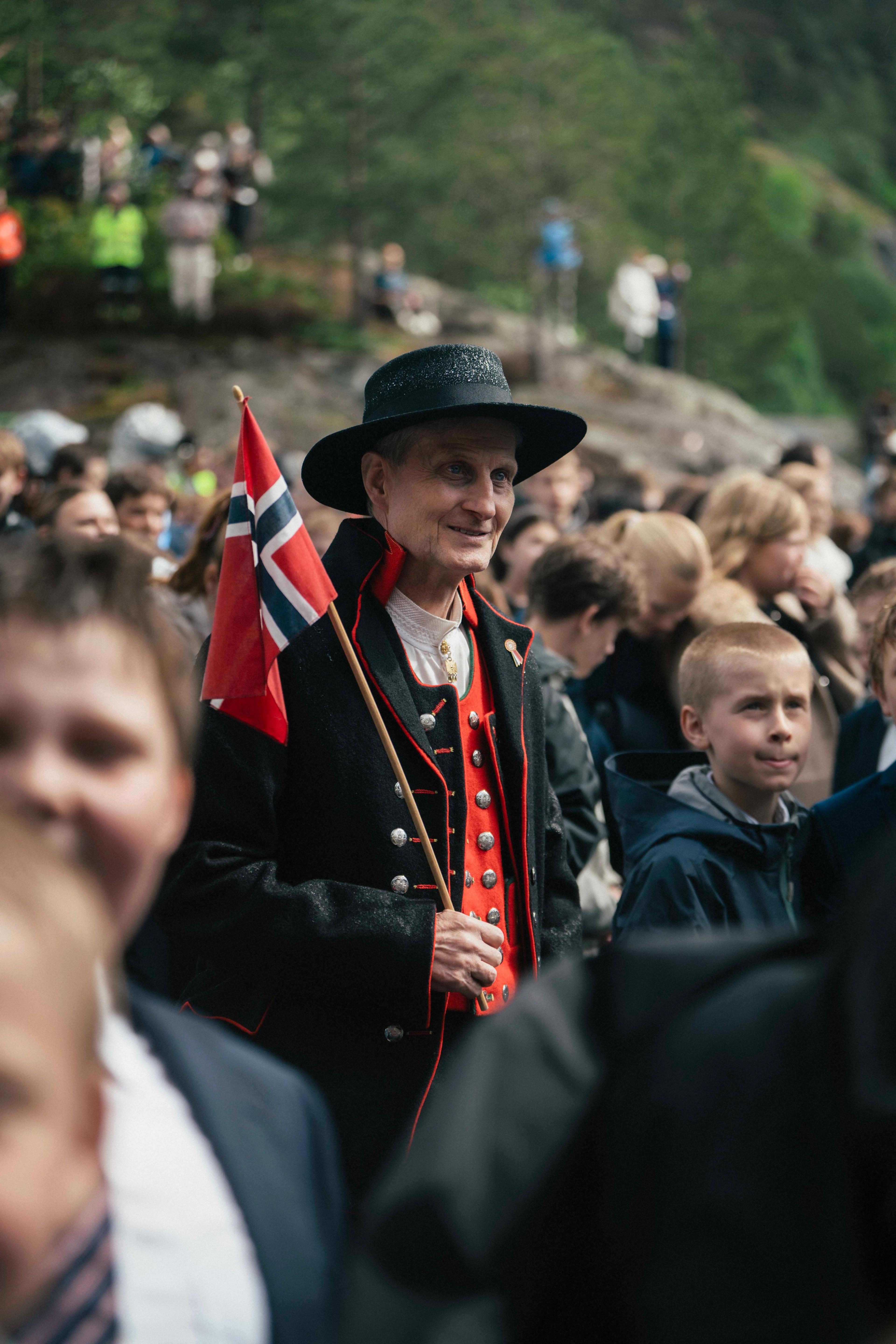 Tett på ein mann i bunad med norsk flagg.