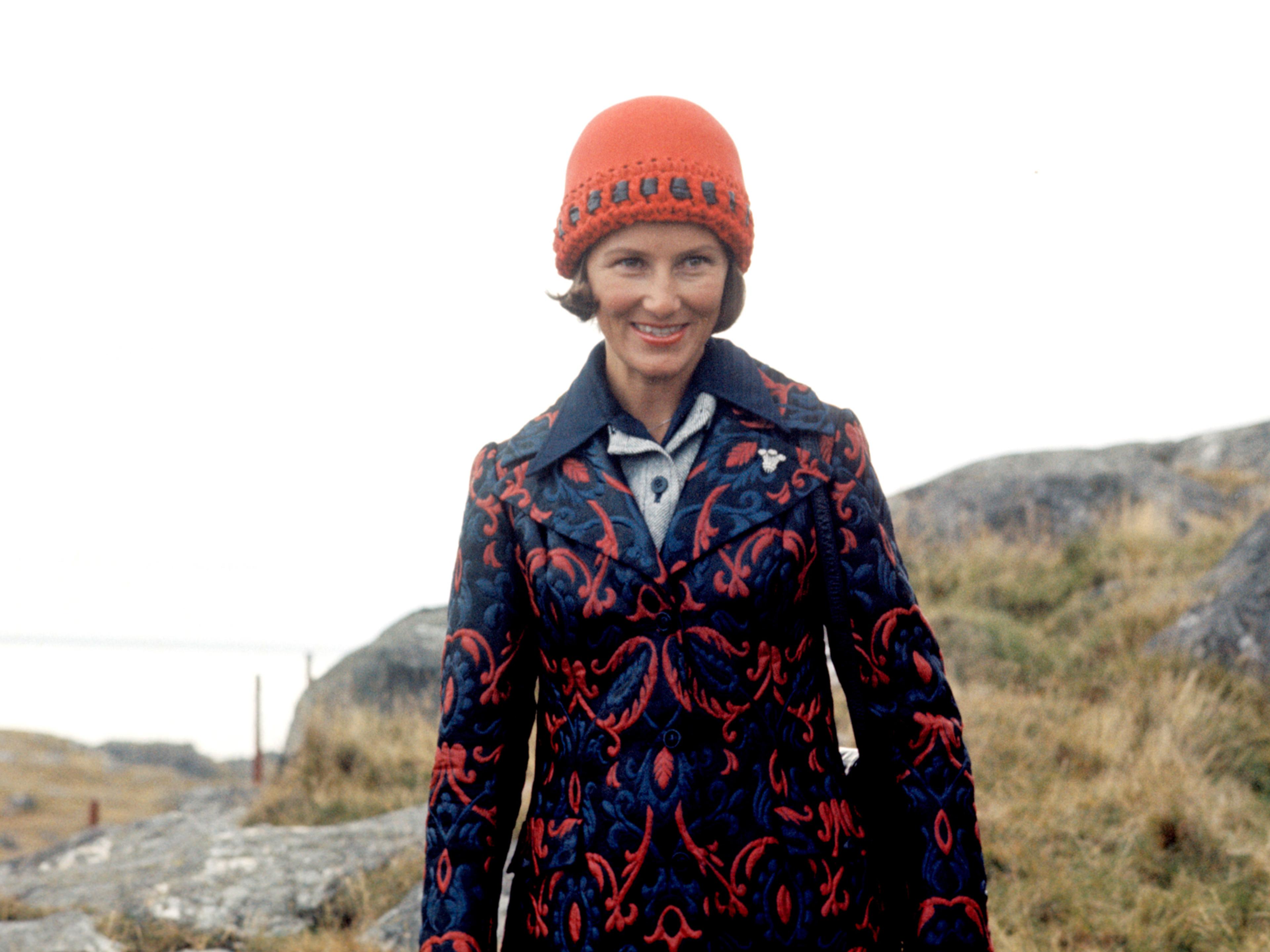 Kronprinsesse Sonja står ute i oransje lue og penjakke.