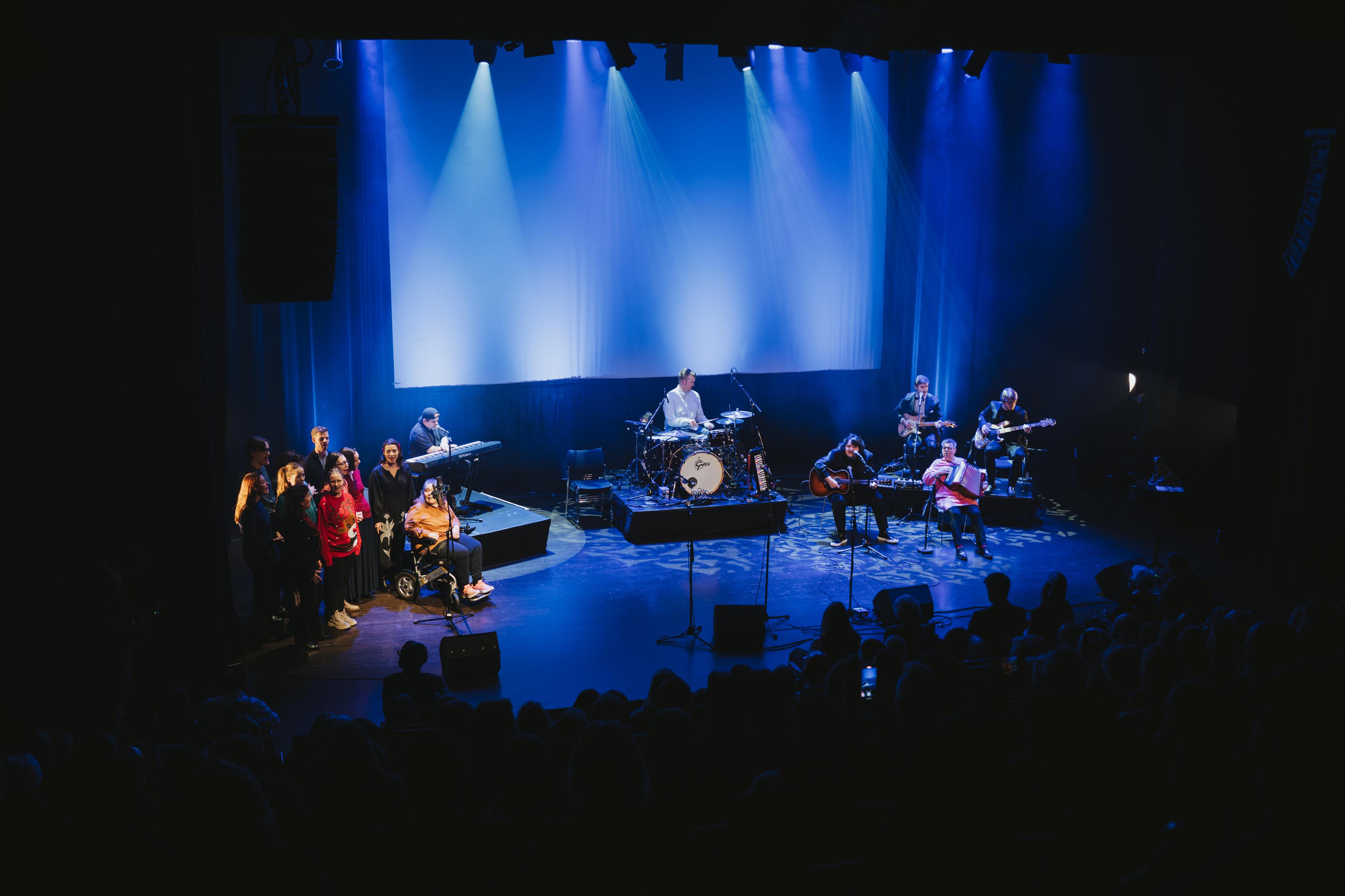 Songarar og musikarar på scena.