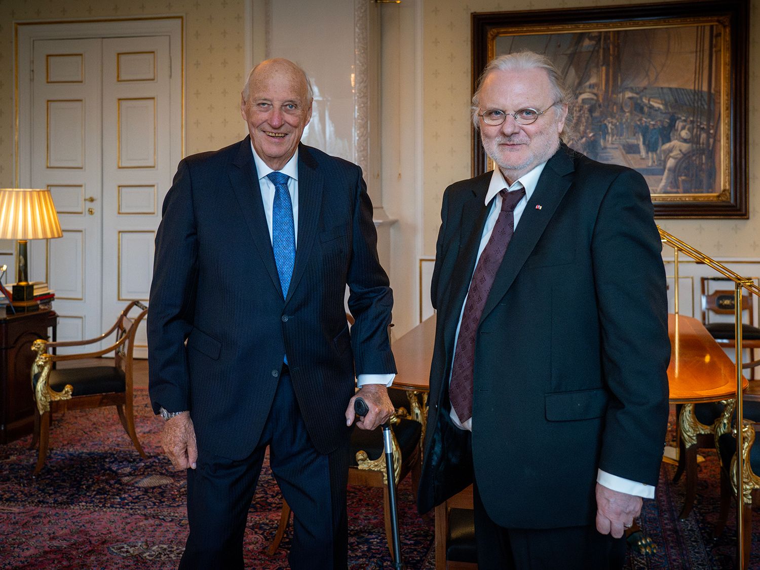 Kongen og forfatteren står smilende på Kongens kontor.