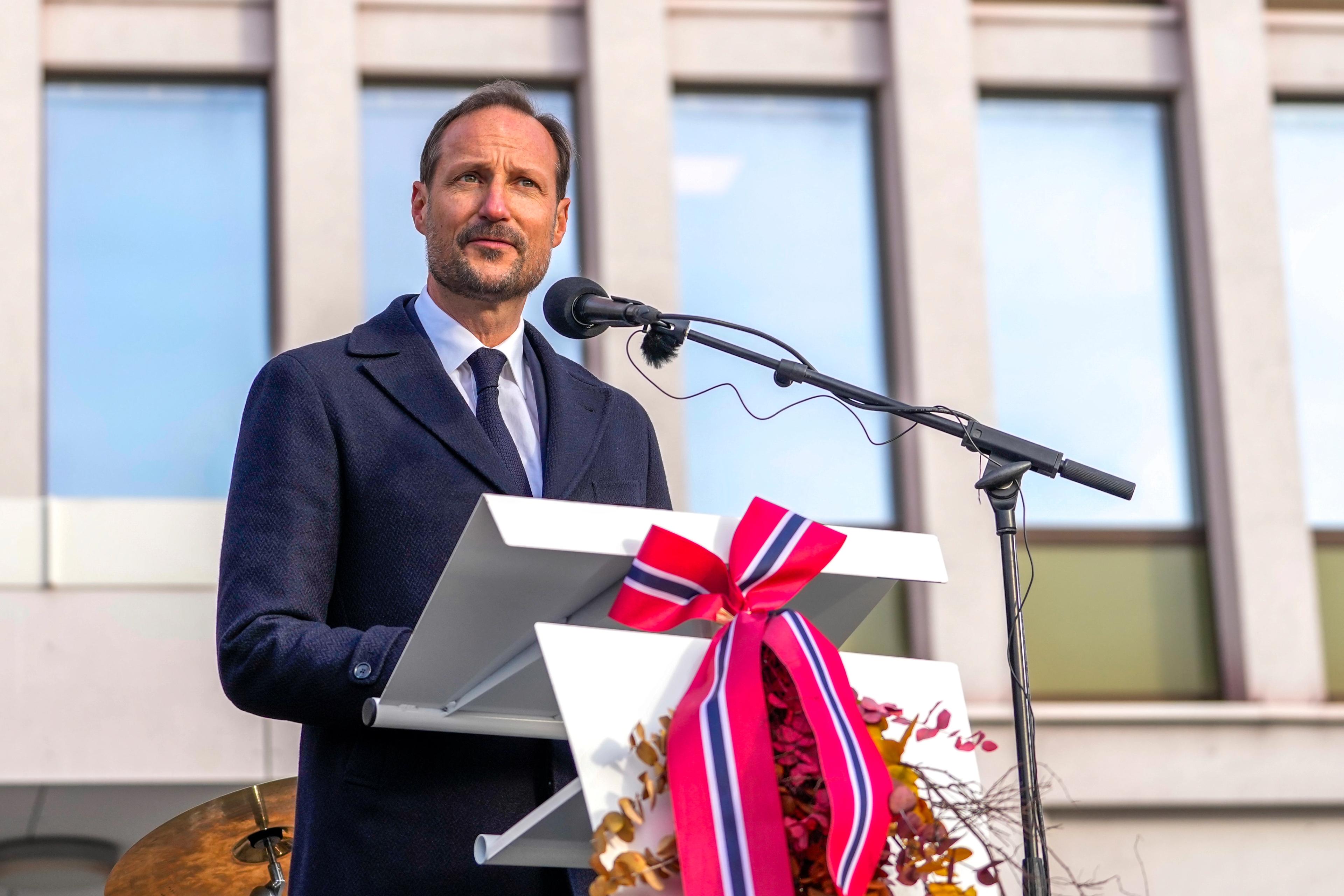 Kong Haakon tå talerstolen. Foran er det festet løv i høstfager og en stor sløyfe i norske farger.