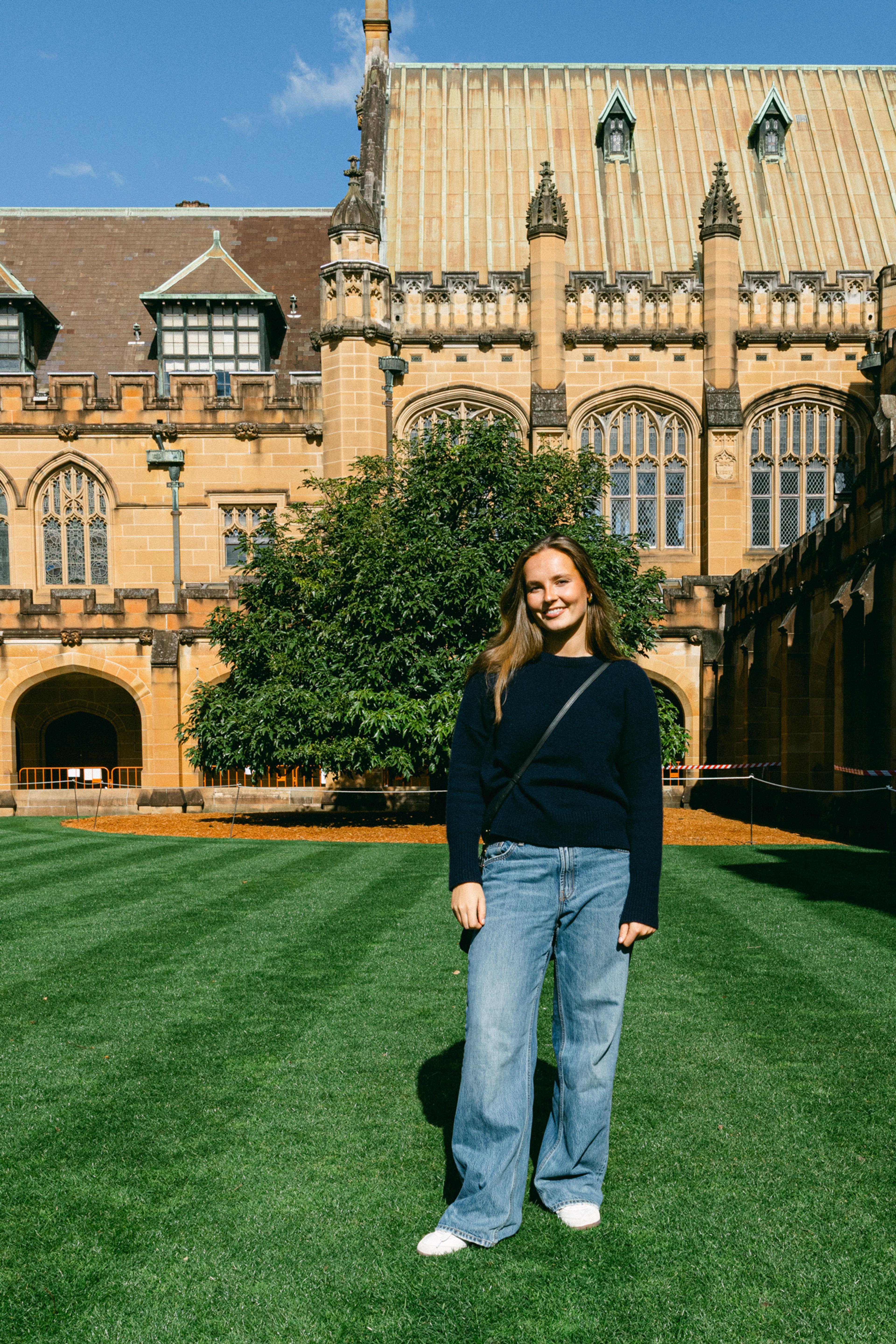 Prinsesse Ingrid Alexandra i jeans og svart genser med ærverdige, gamle bygninger i bakgrunnene.
