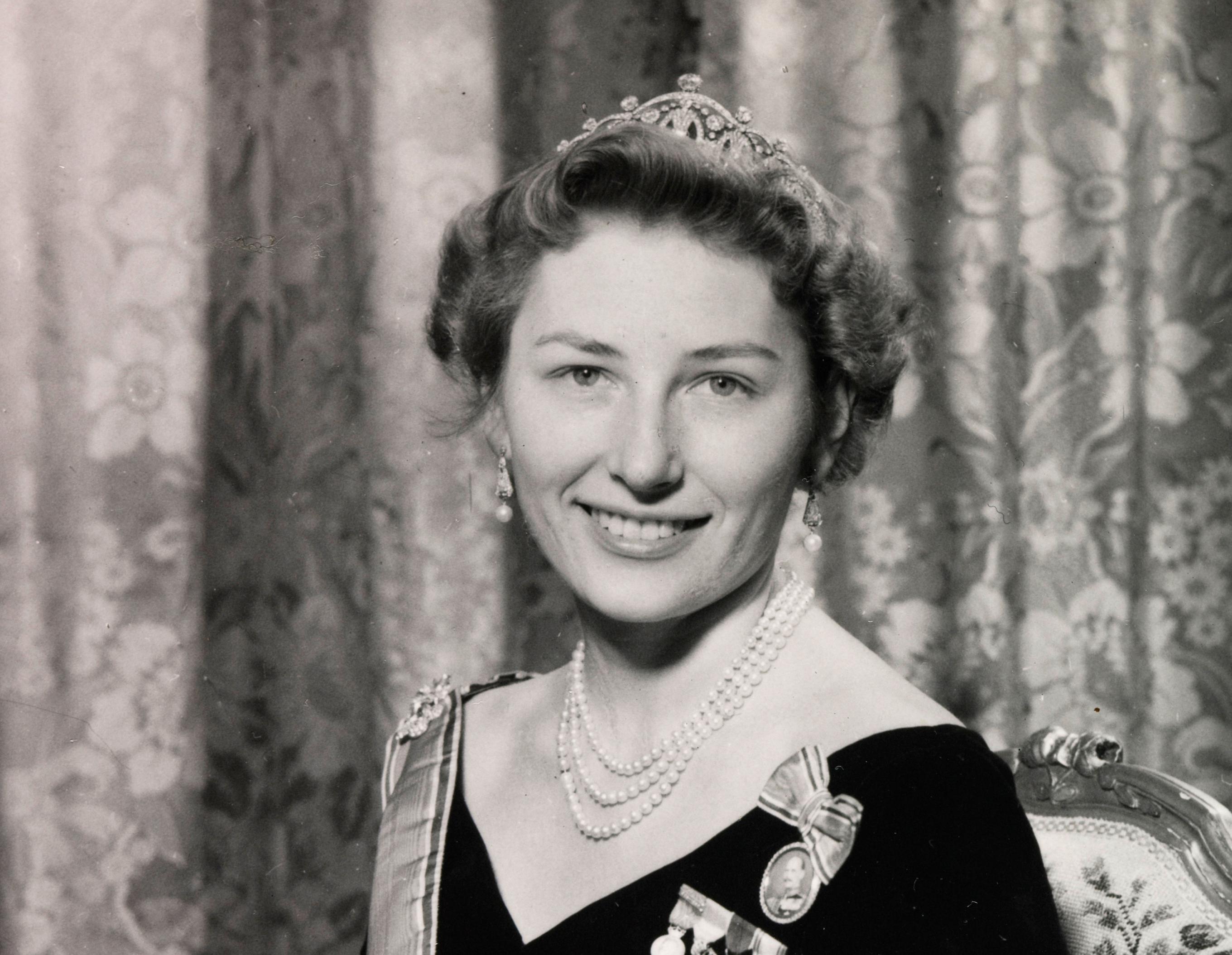 Prinsesse Astrid sitter i kjole med ordener og diadem.