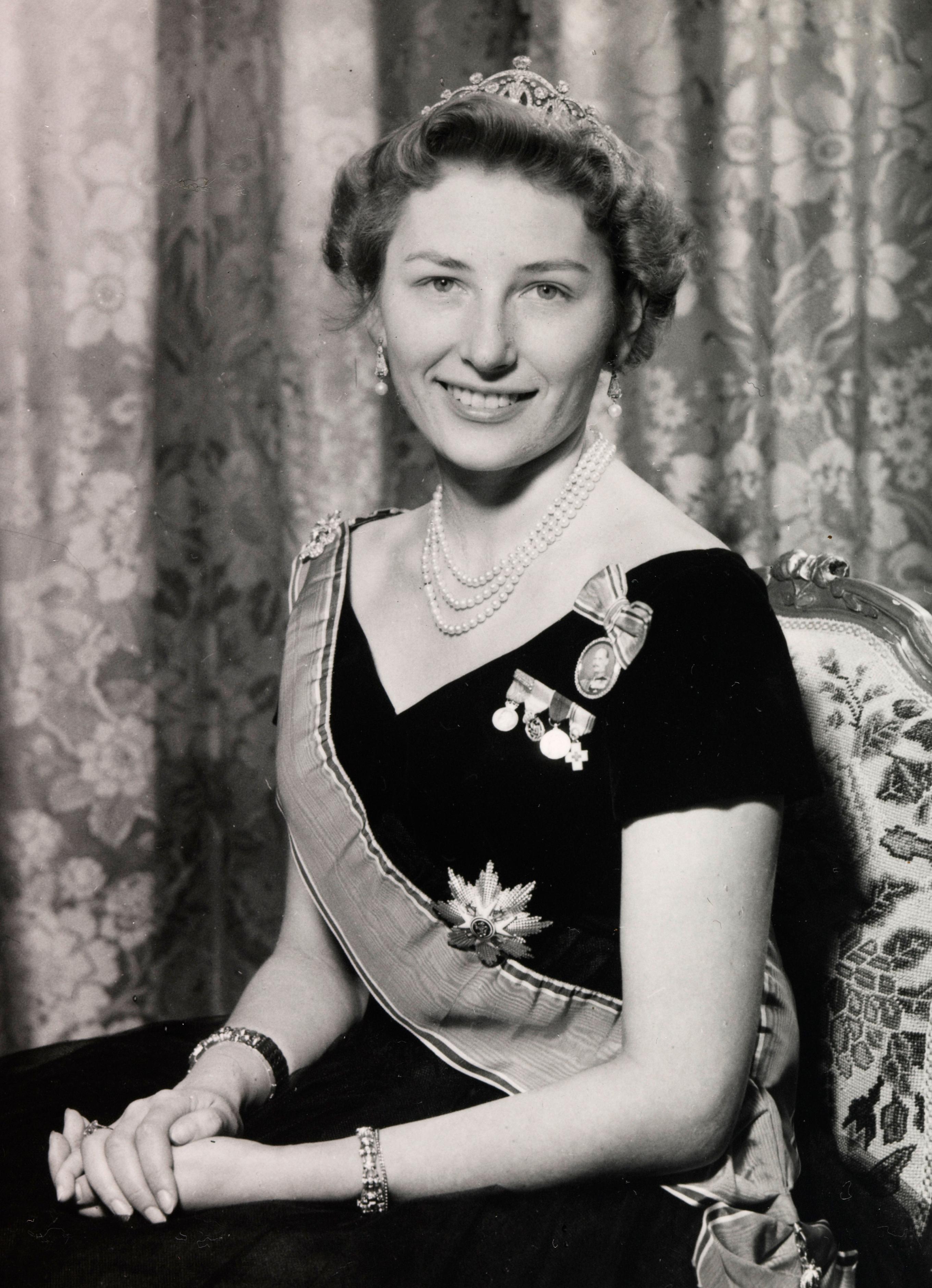 Prinsesse Astrid sitter i kjole med ordener og diadem.