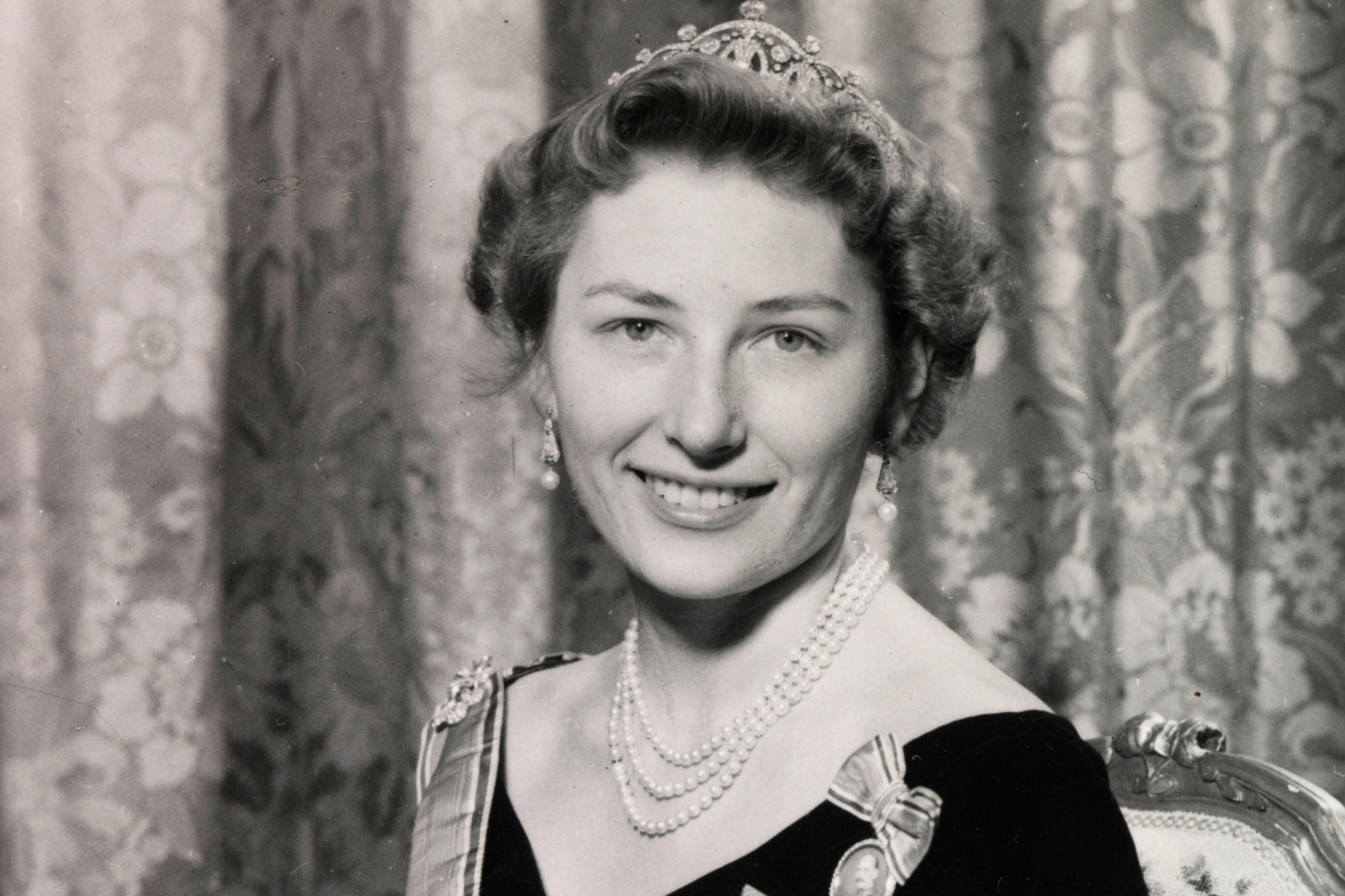 Prinsesse Astrid sitter i kjole med ordener og diadem.