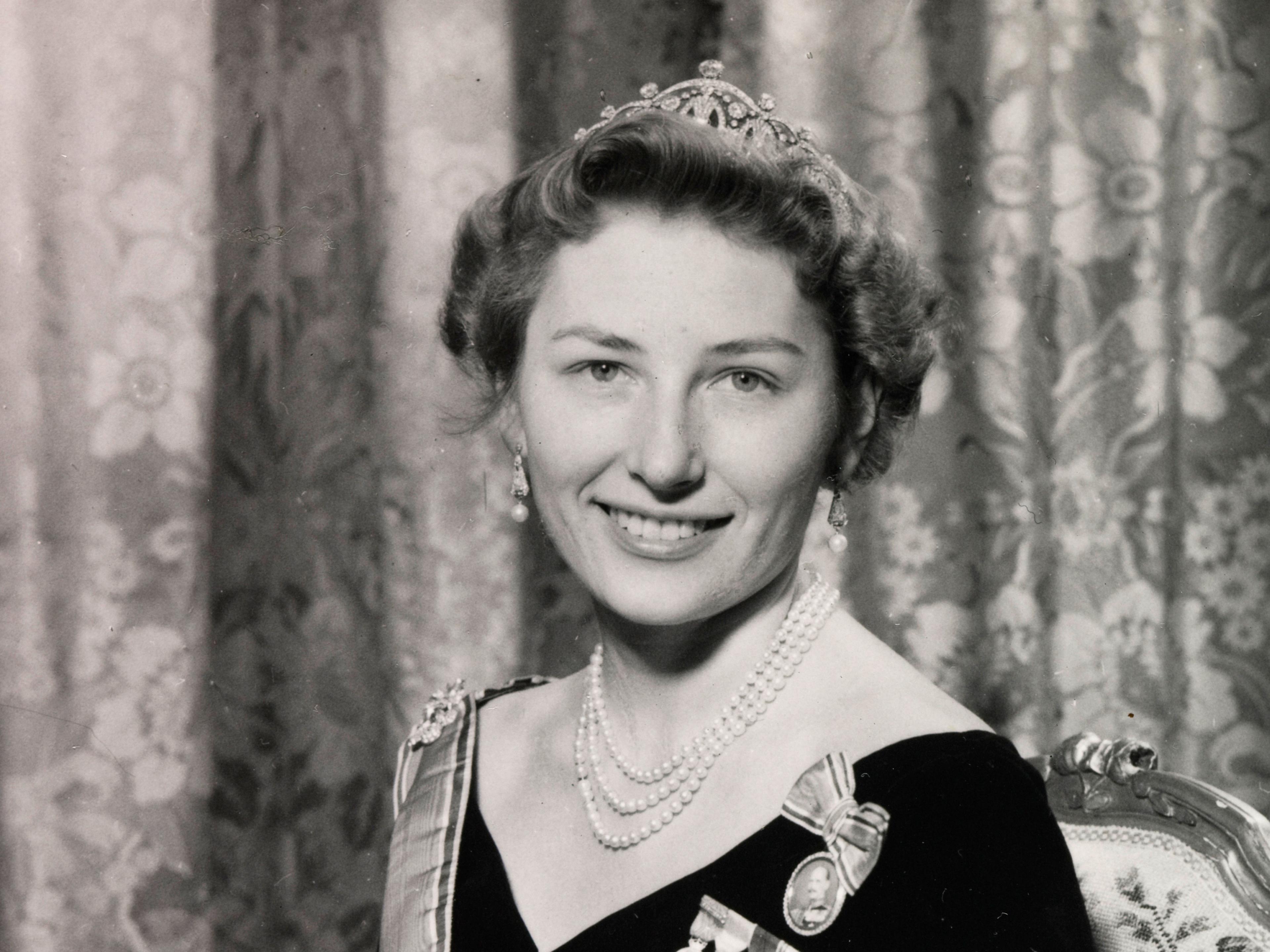 Prinsesse Astrid sitter i kjole med ordener og diadem.