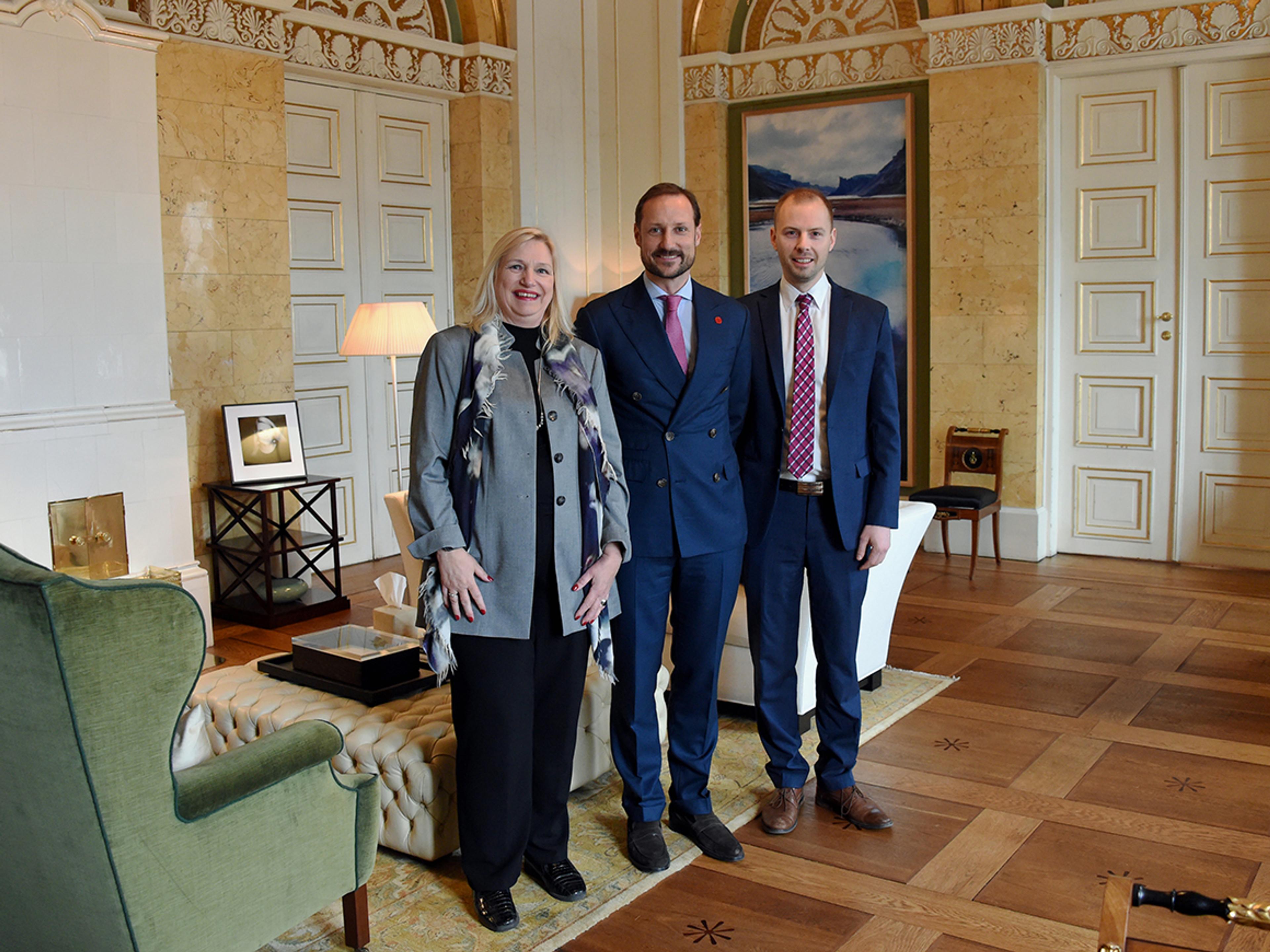 To representanter for Nordlysfestivalen står sammen med Kronprinsen på hans kontor.