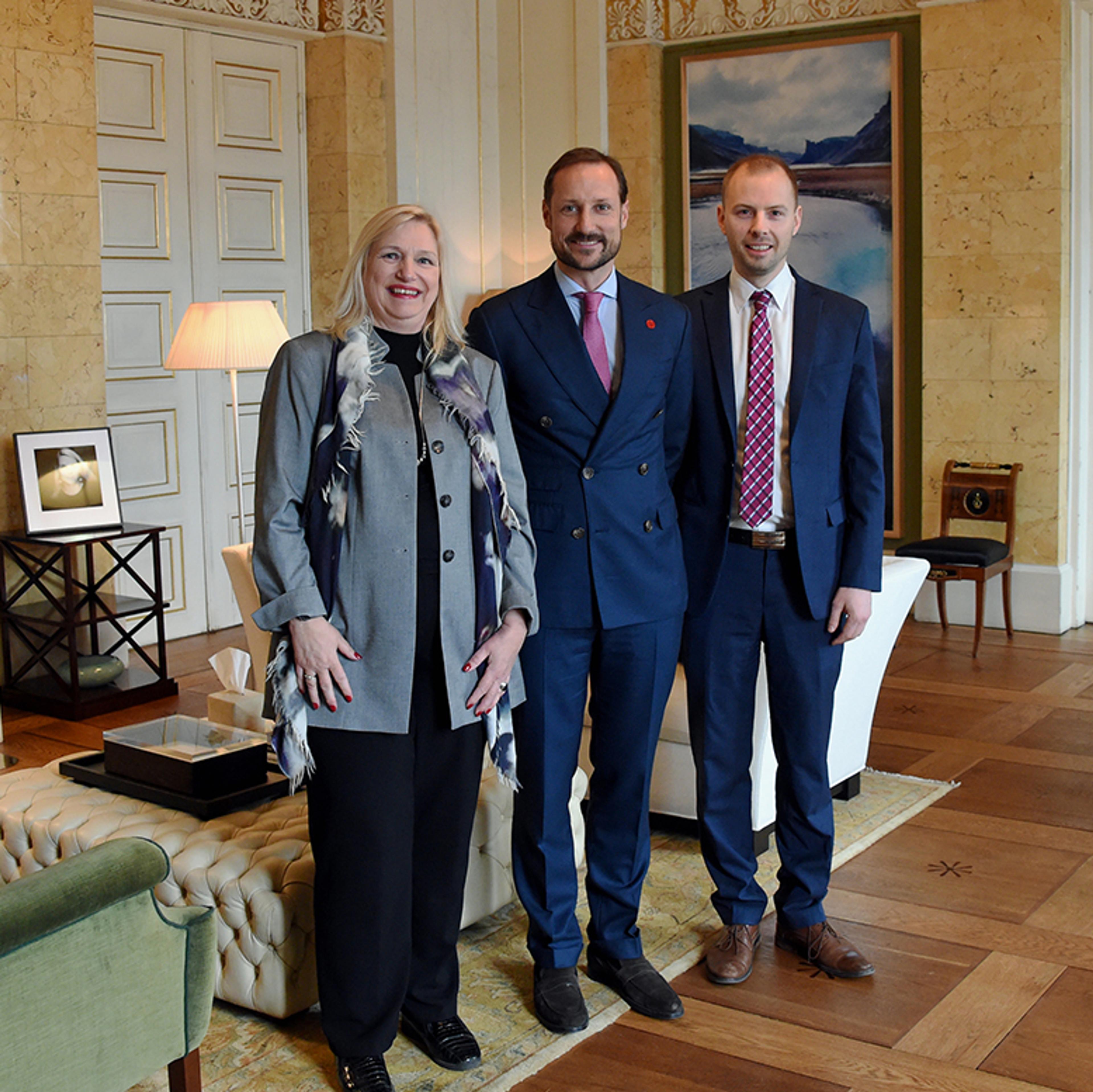 To representanter for Nordlysfestivalen står sammen med Kronprinsen på hans kontor.