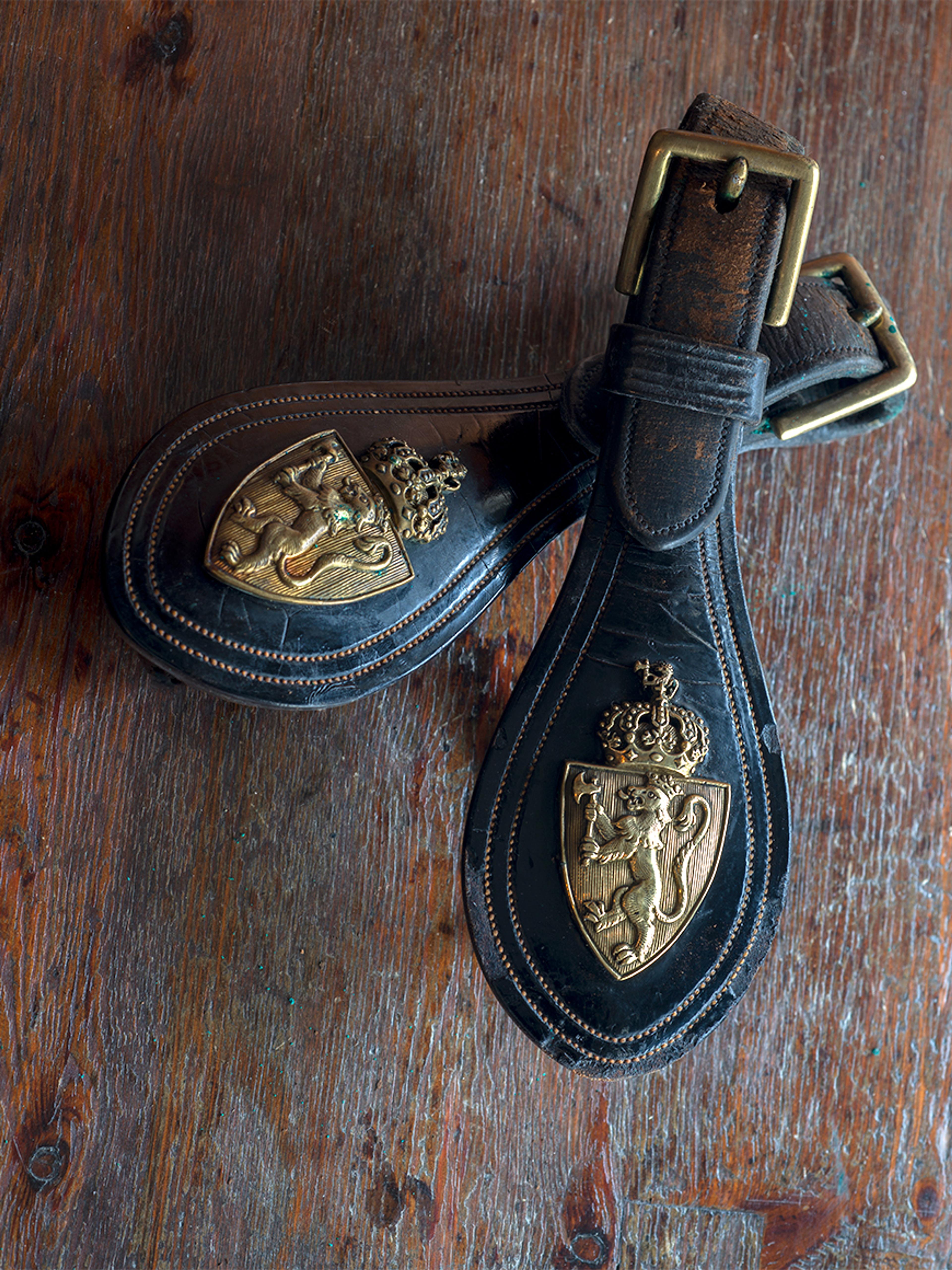 Nærbilde av spenner preget med riksvåpenet.