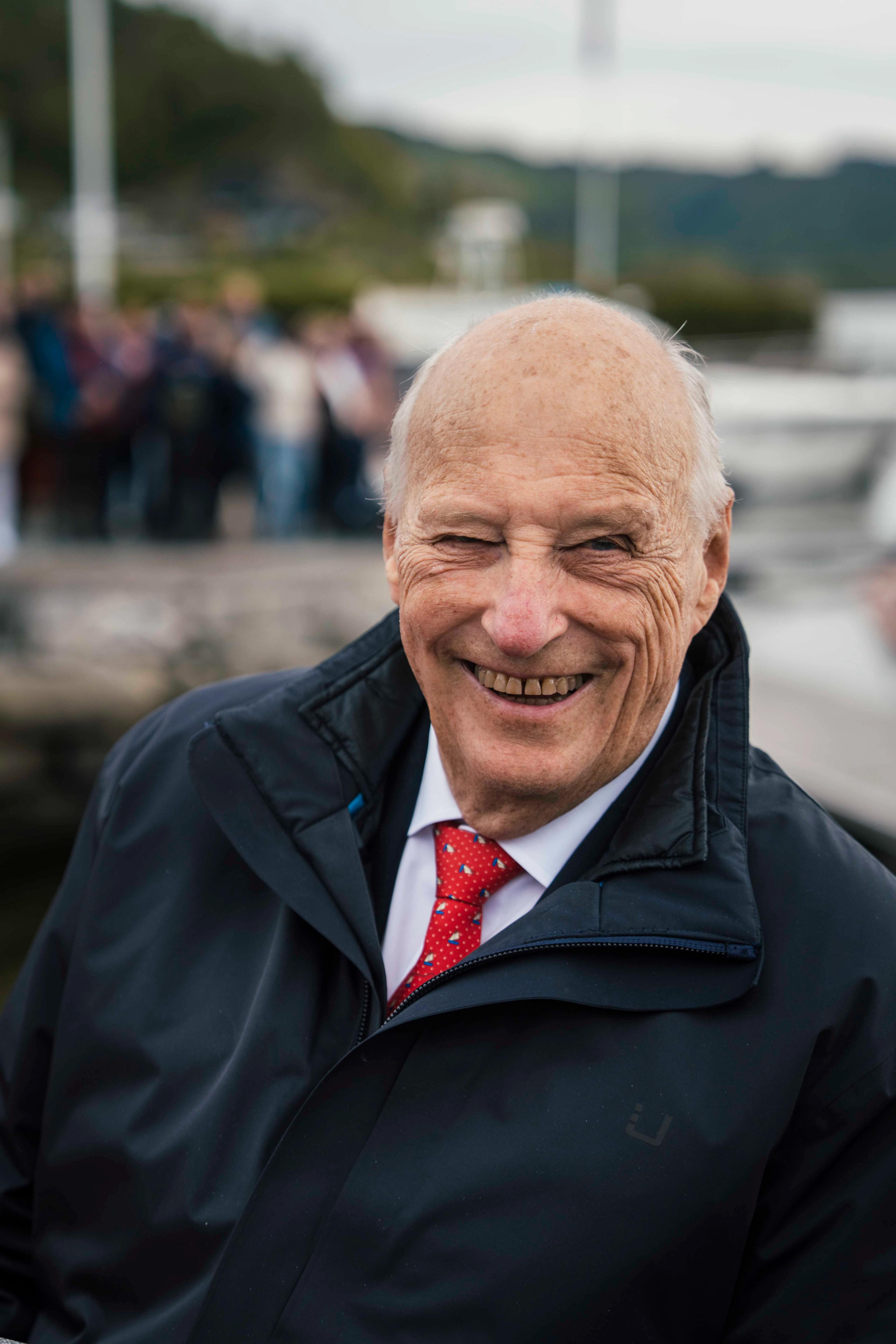 Portrettbilete av Kong Harald som smiler.