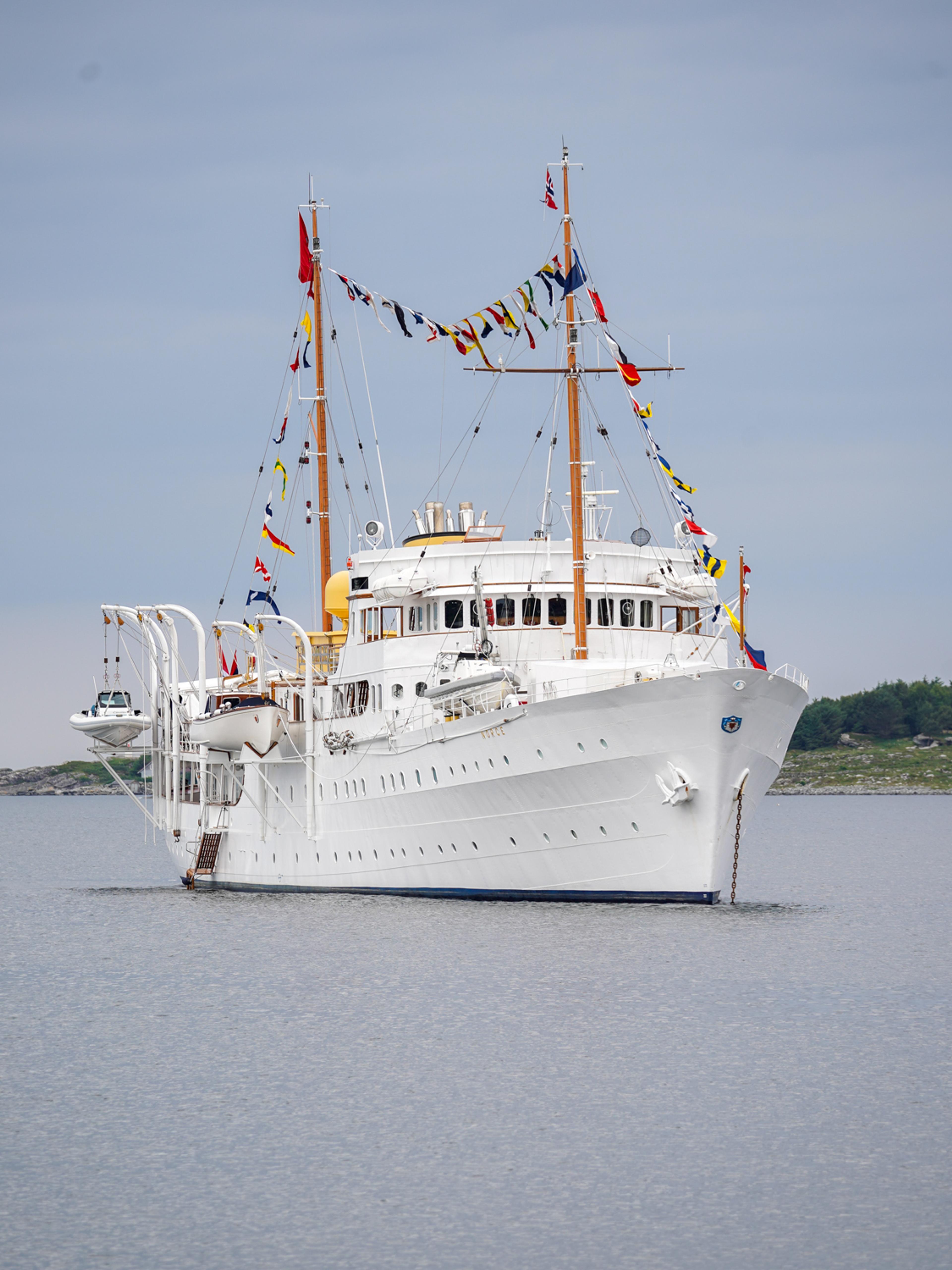 Skipet sett delvis forfra. Det henger rader med festflagg fra mastene.