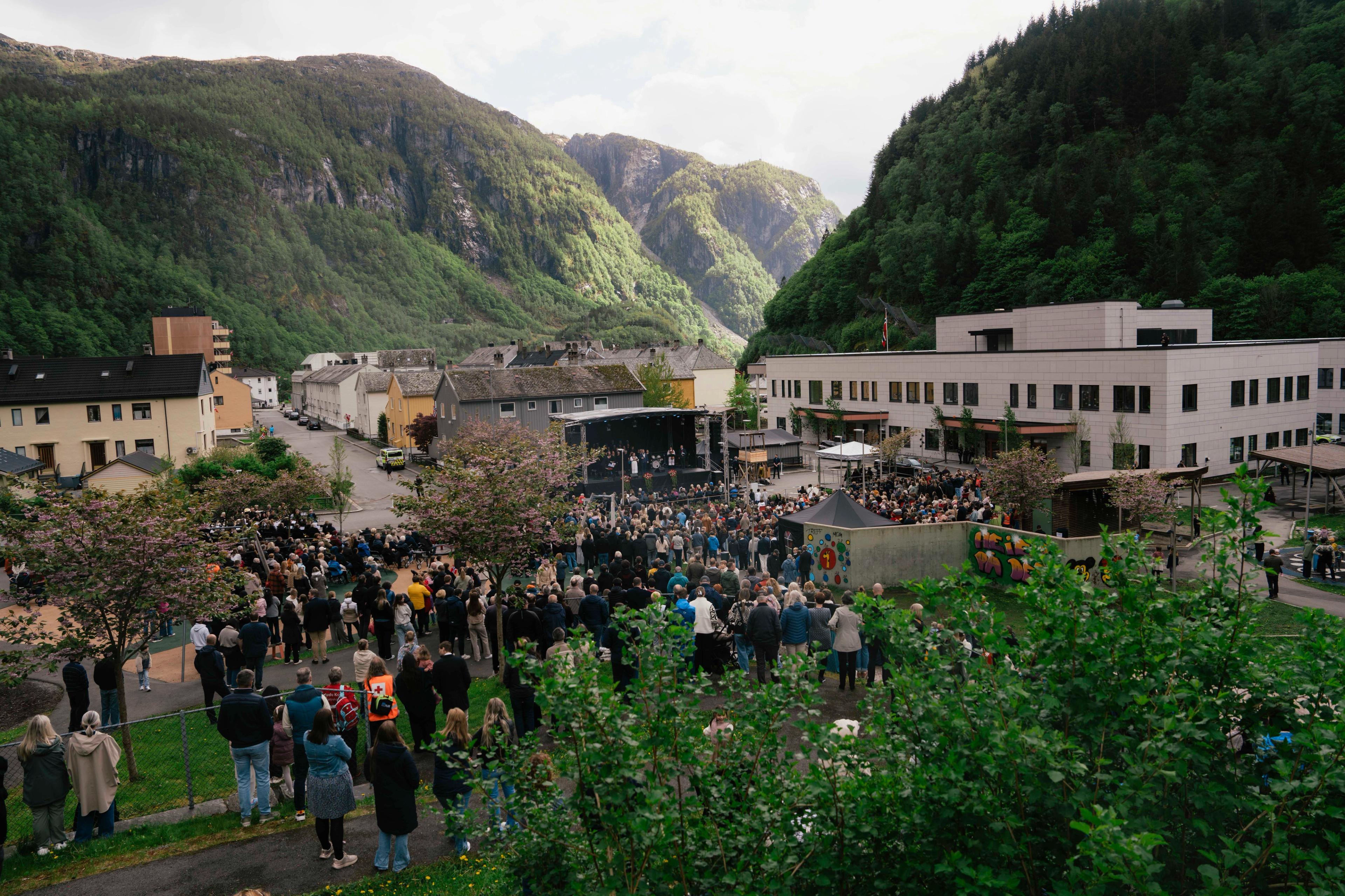 Oversiktsbilete over folk, skule og fjell.