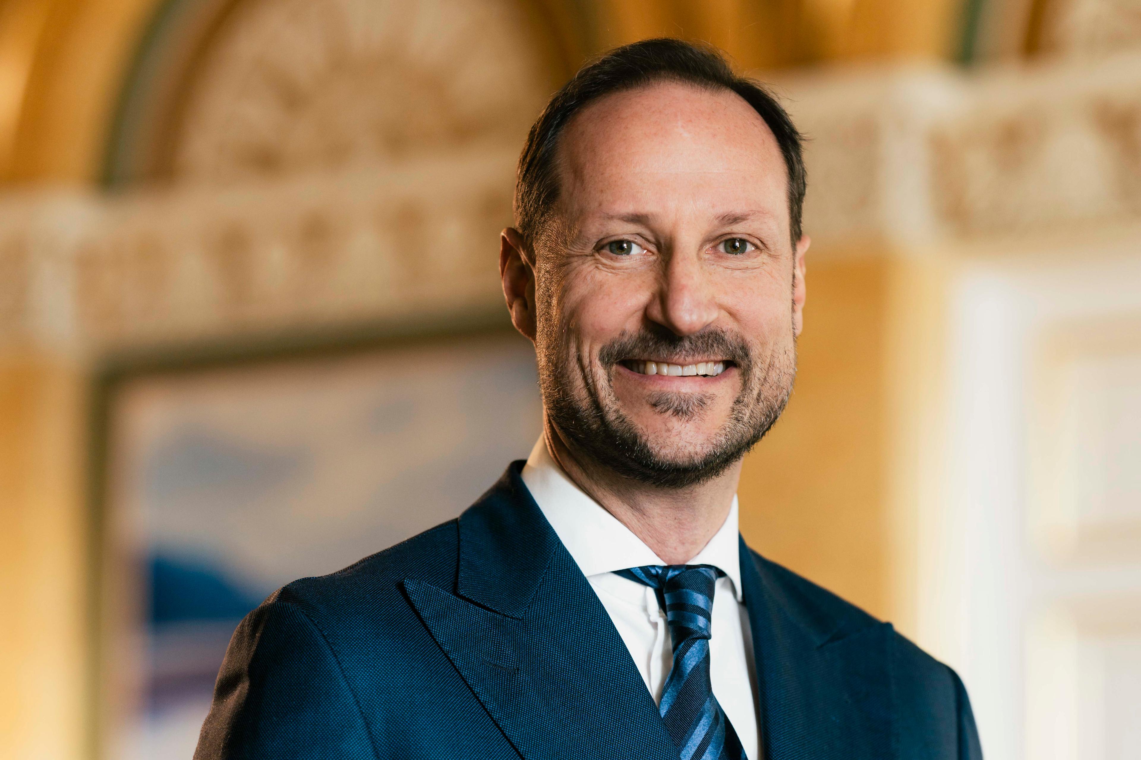 Portrett av Kronprins Haakon tatt i hvit skjorte mørkeblå dress med slips.