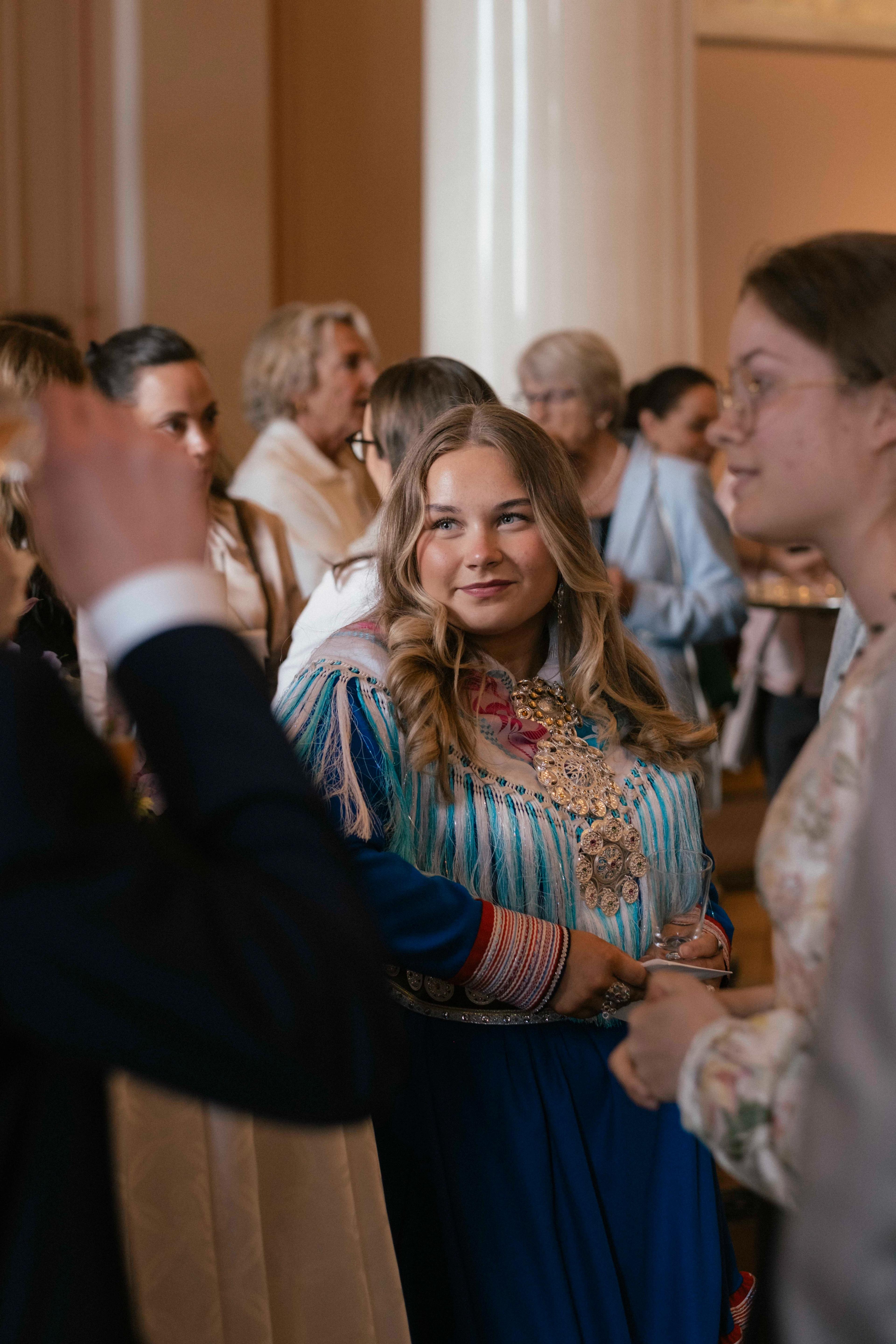 Folk i samtale rundt ståbord i salen.