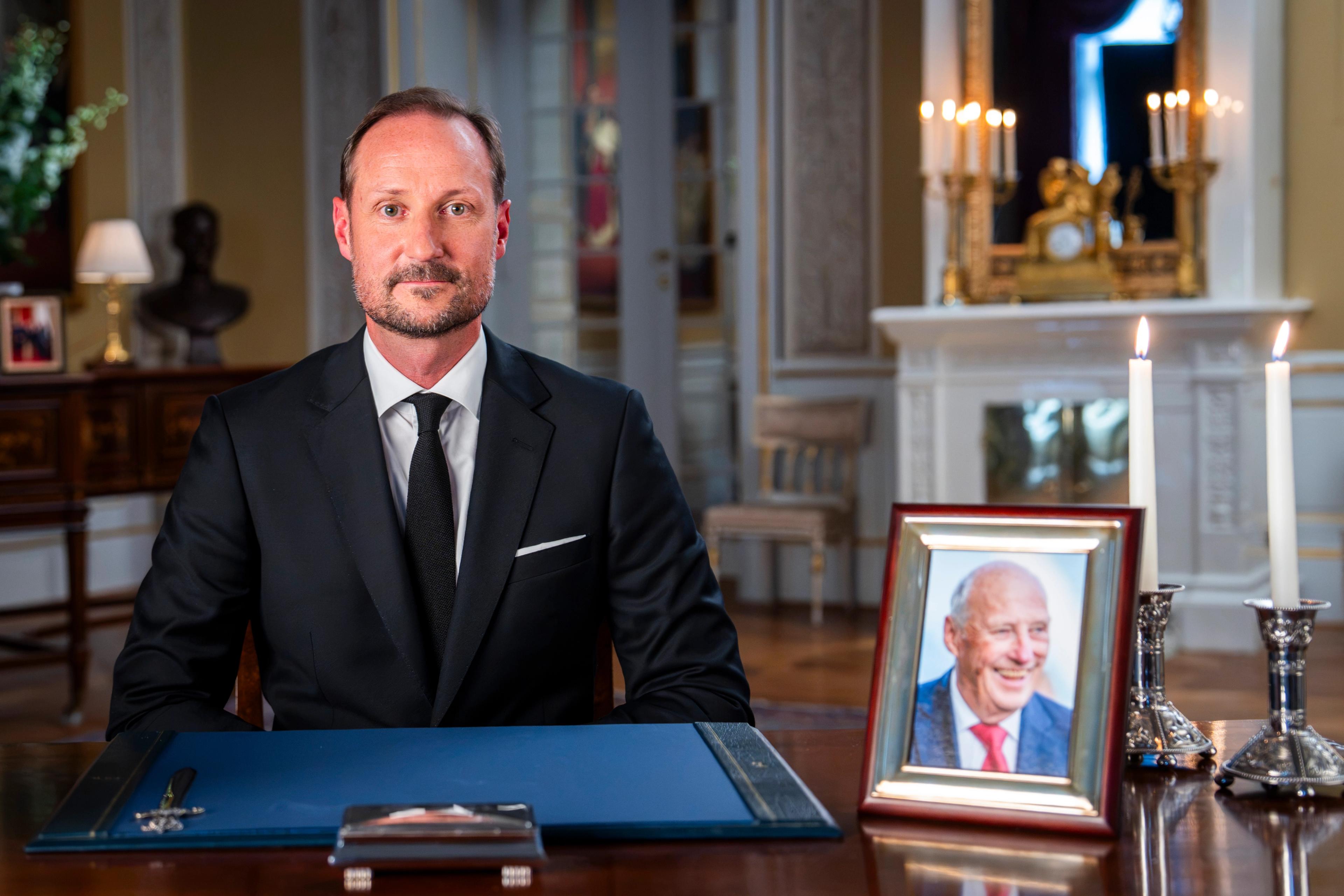 Kongen bak sitt skrivebord med ulike gjenstander.