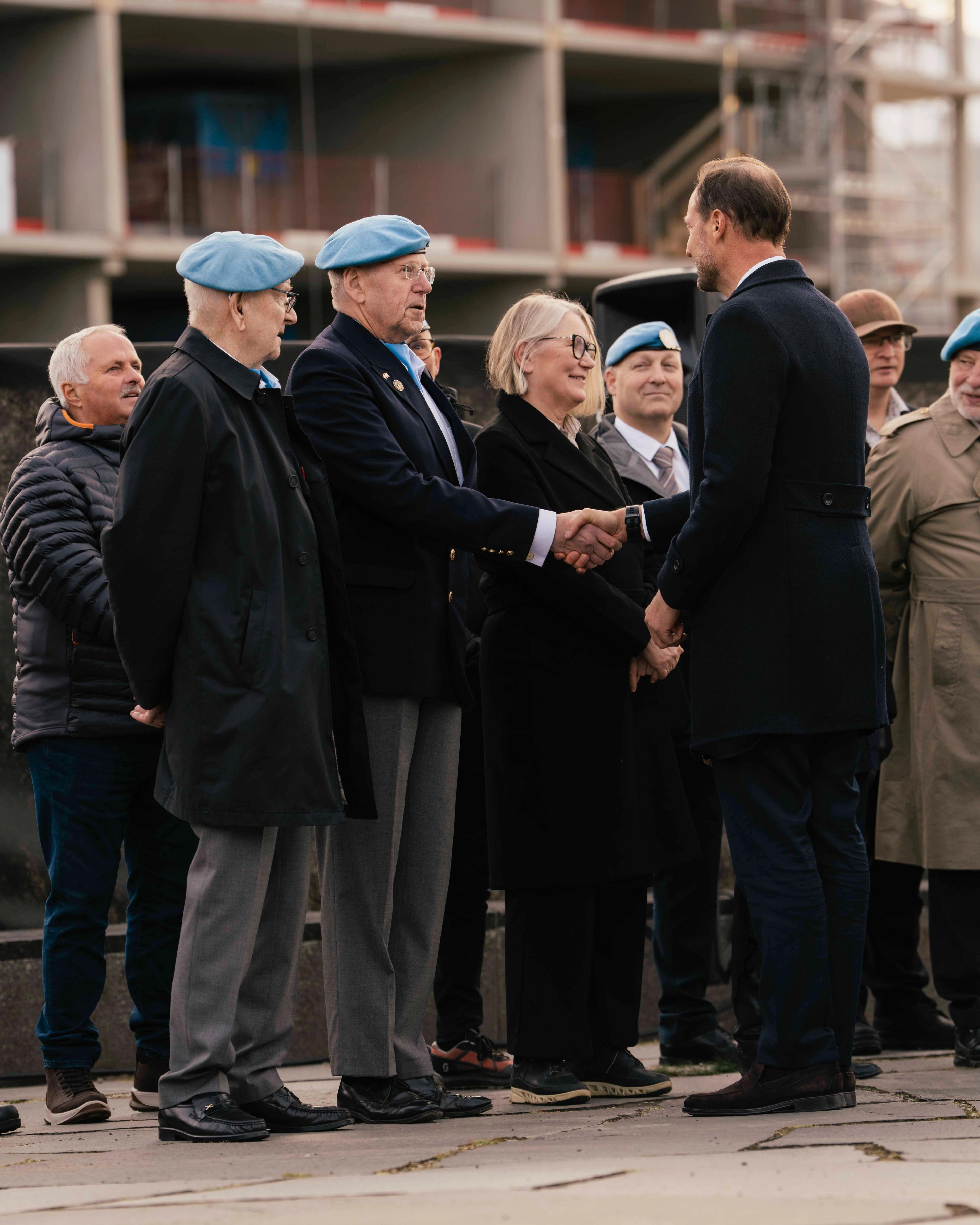 Kongen håndhilser på veteraner som står oppstilt på rekke