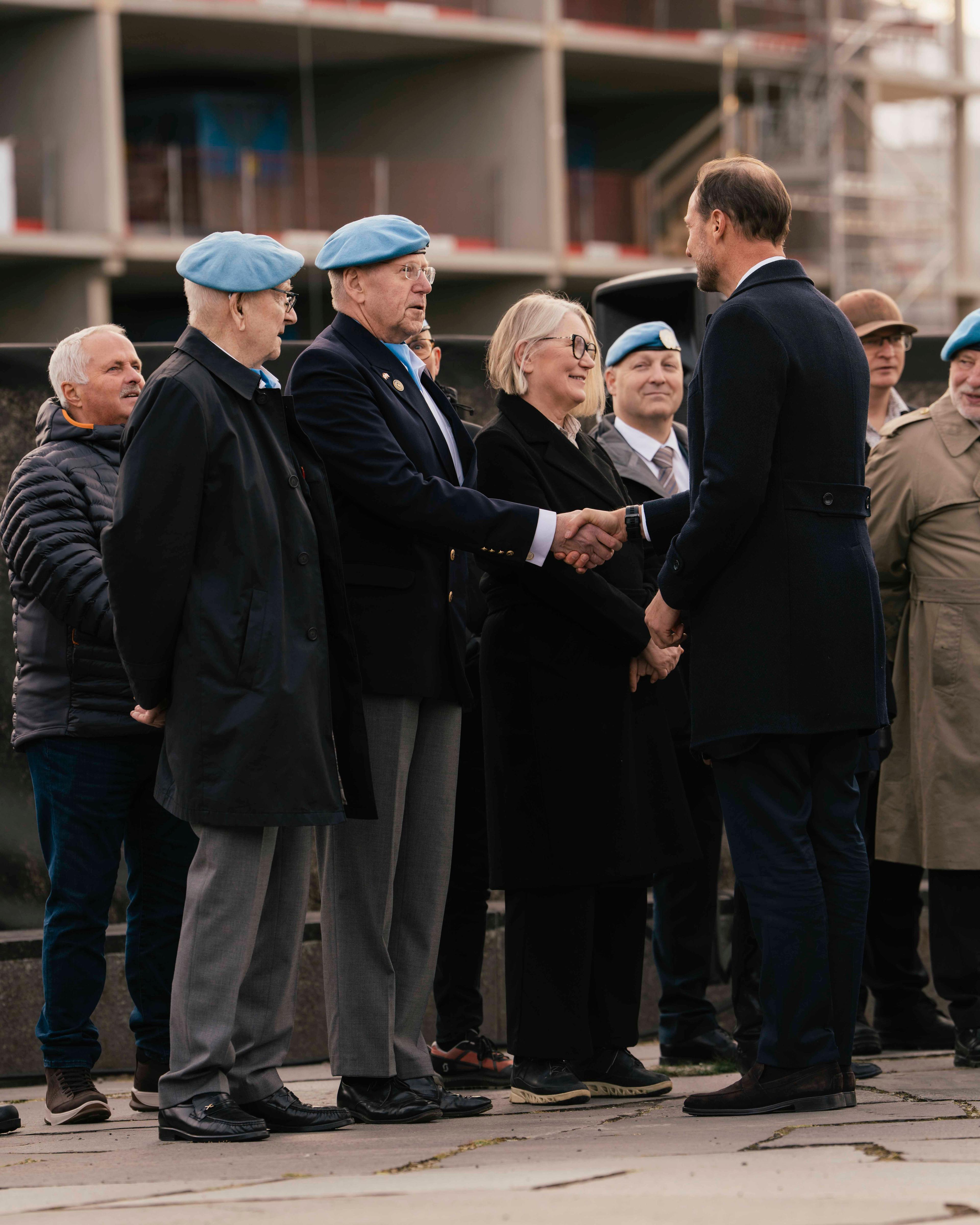 Kongen håndhilser på veteraner som står oppstilt på rekke