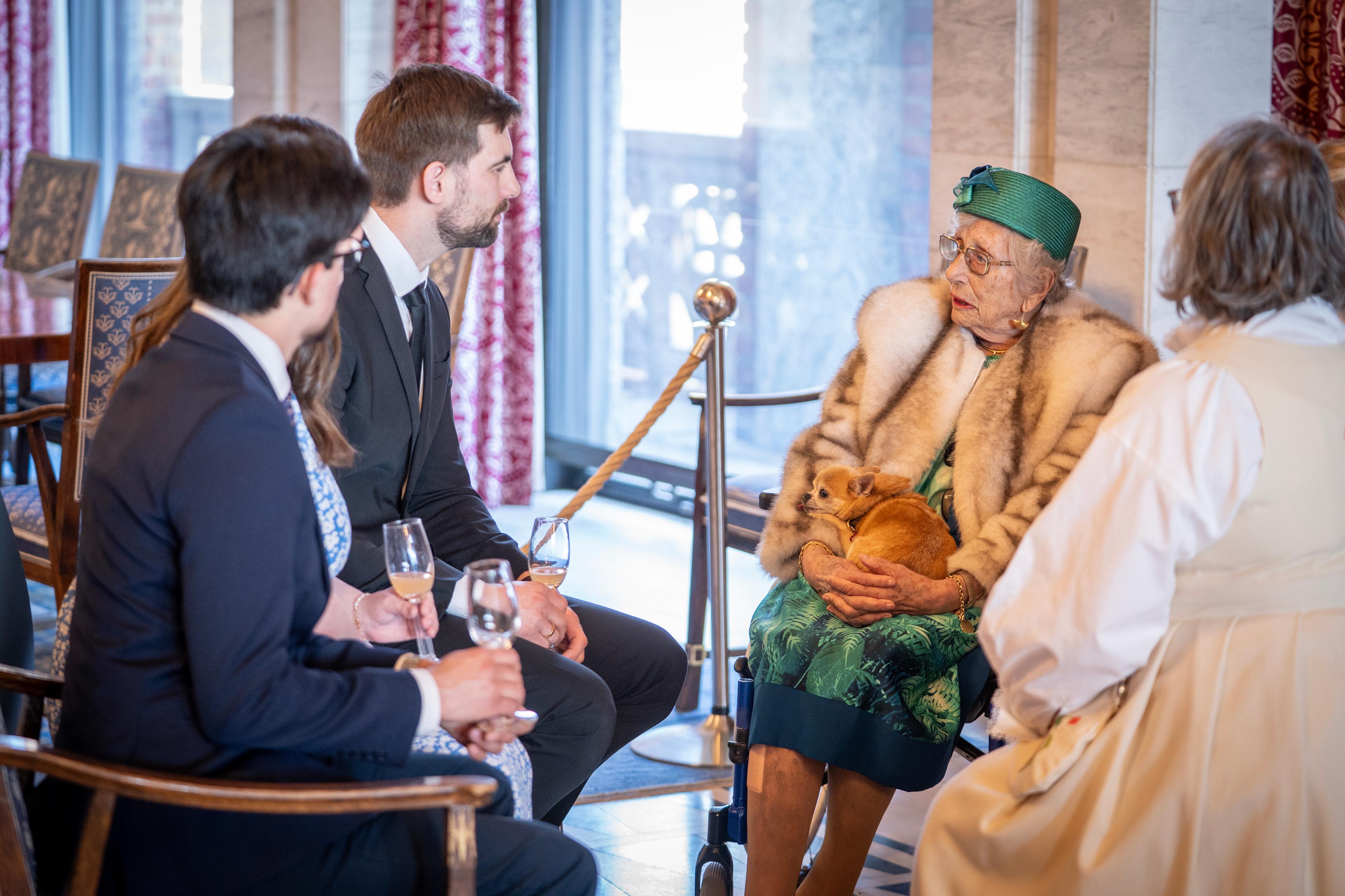 Prinsesse Astrid sitter i en ring med mennesker og samtaler.