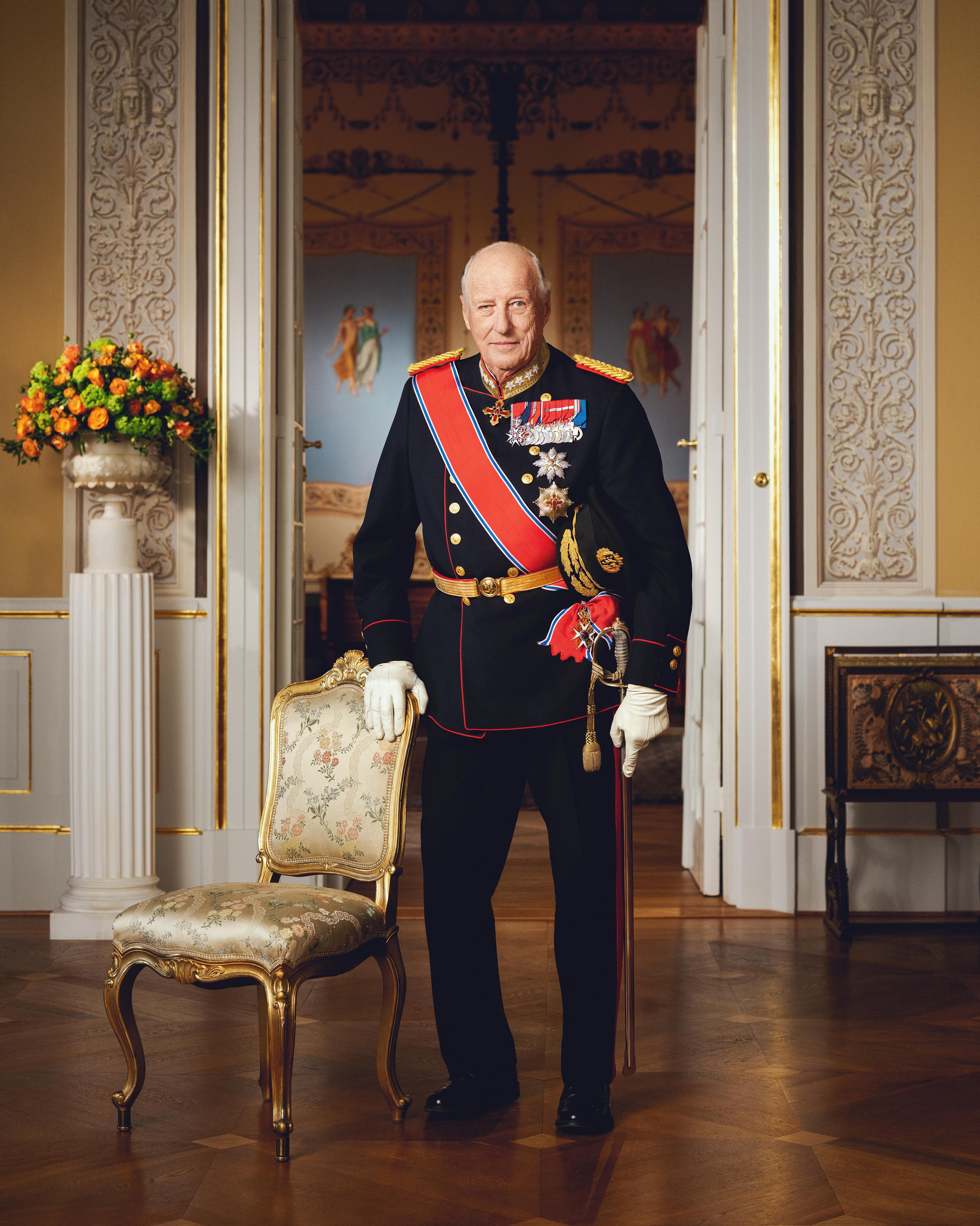 Kong Harald stående i gallauniform med ordener og medaljer.