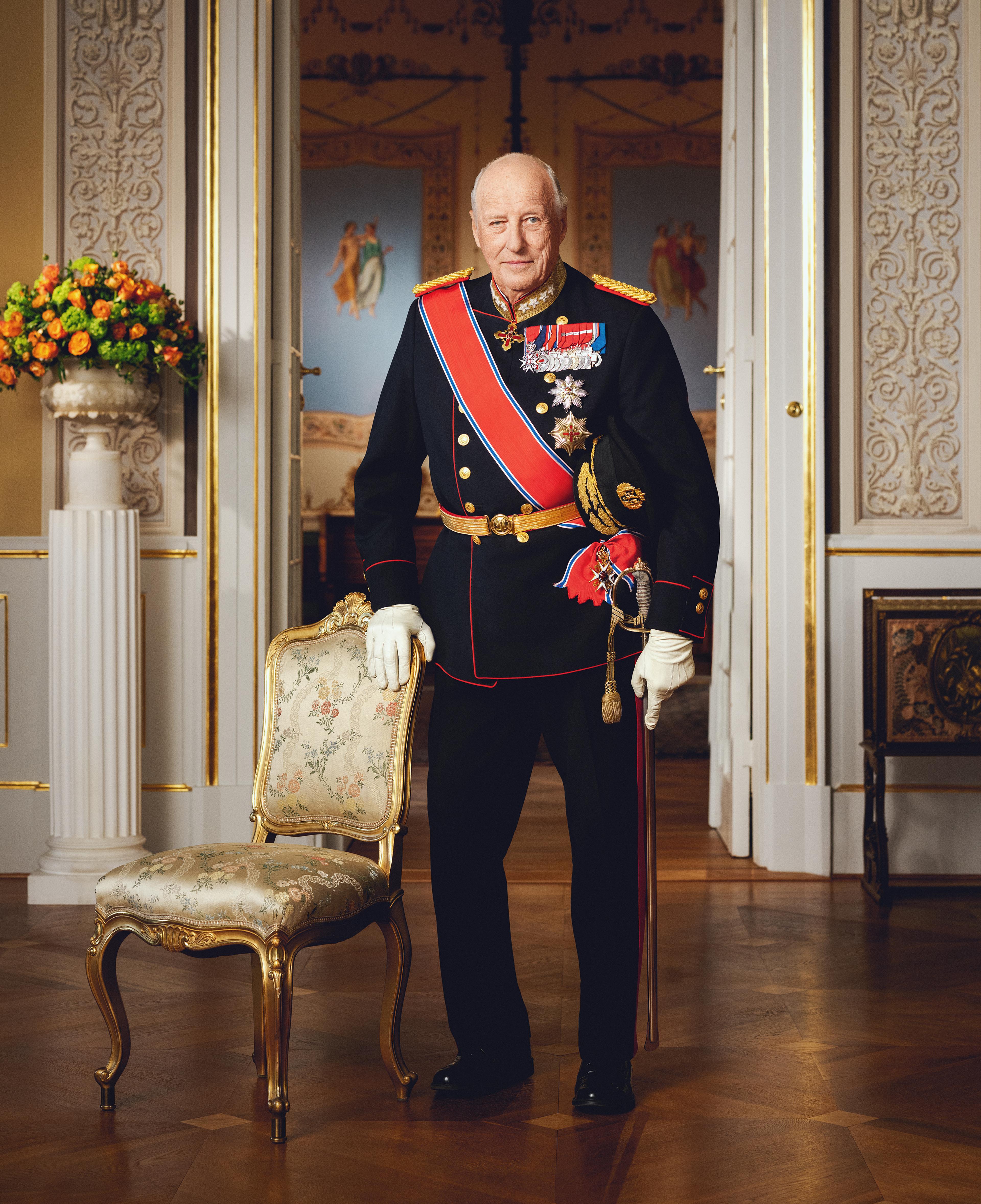 Kong Harald stående i gallauniform med ordener og medaljer.