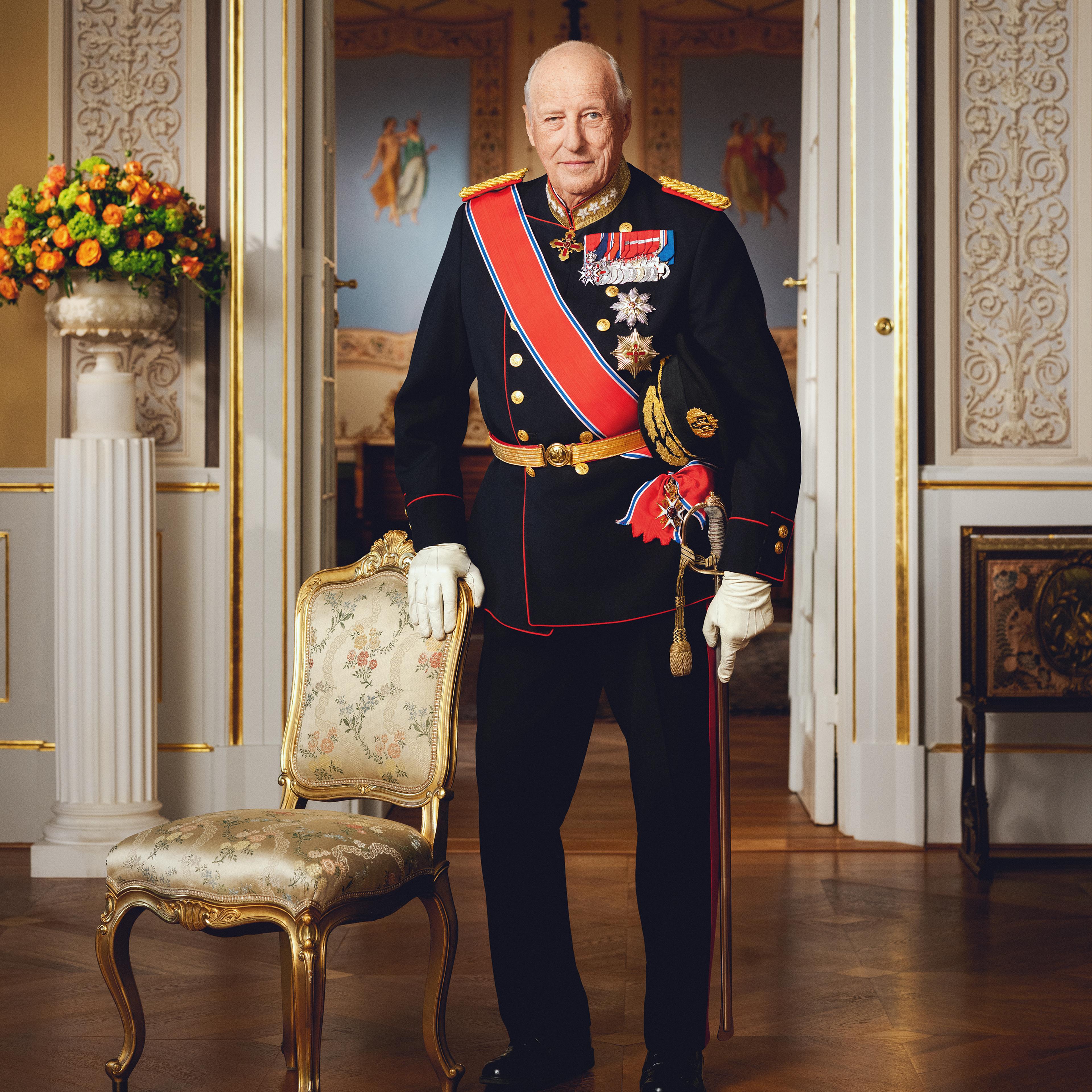 Kong Harald stående i gallauniform med ordener og medaljer.