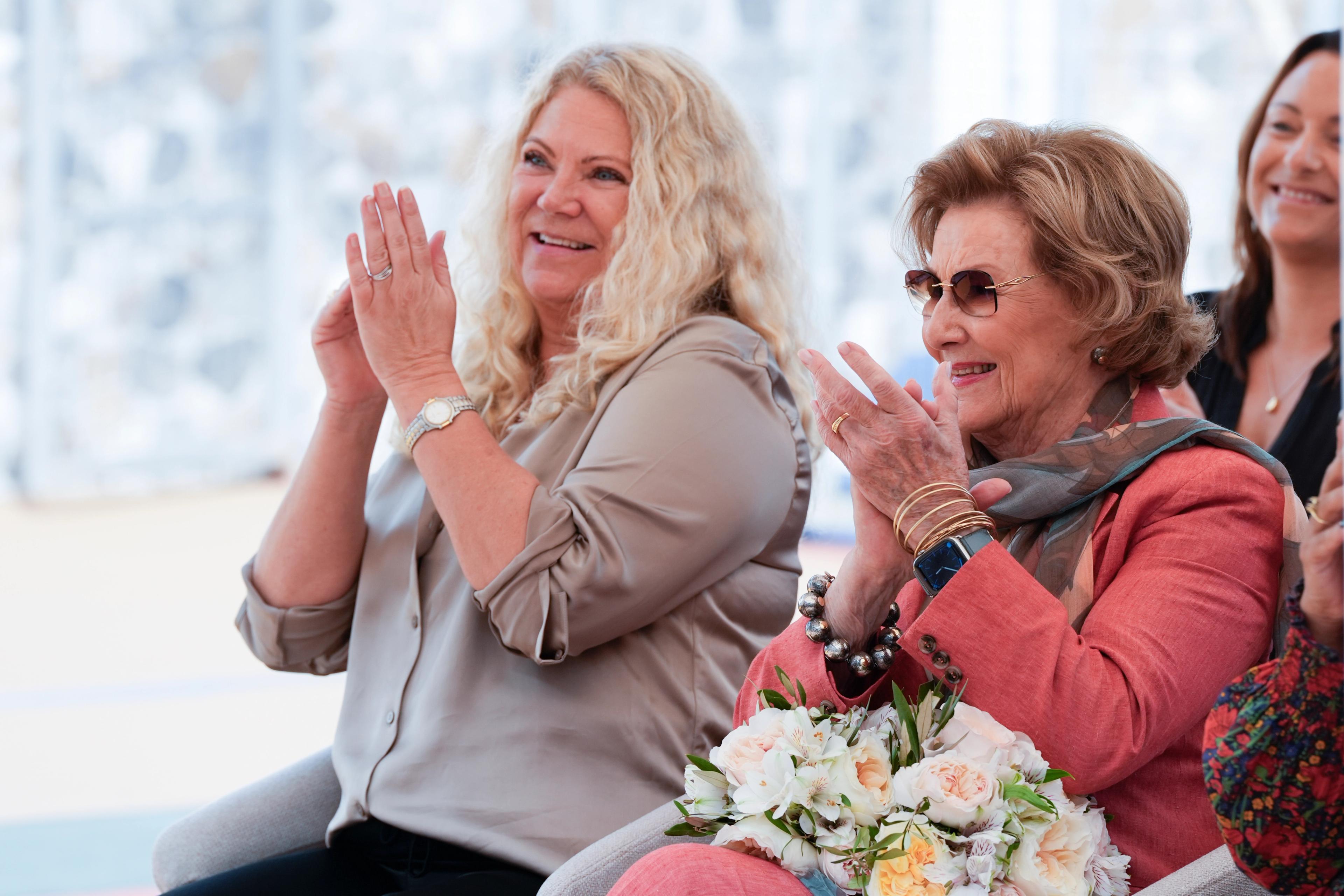 Rektor og Dronning Sonja smiler bredt mens de klapper.