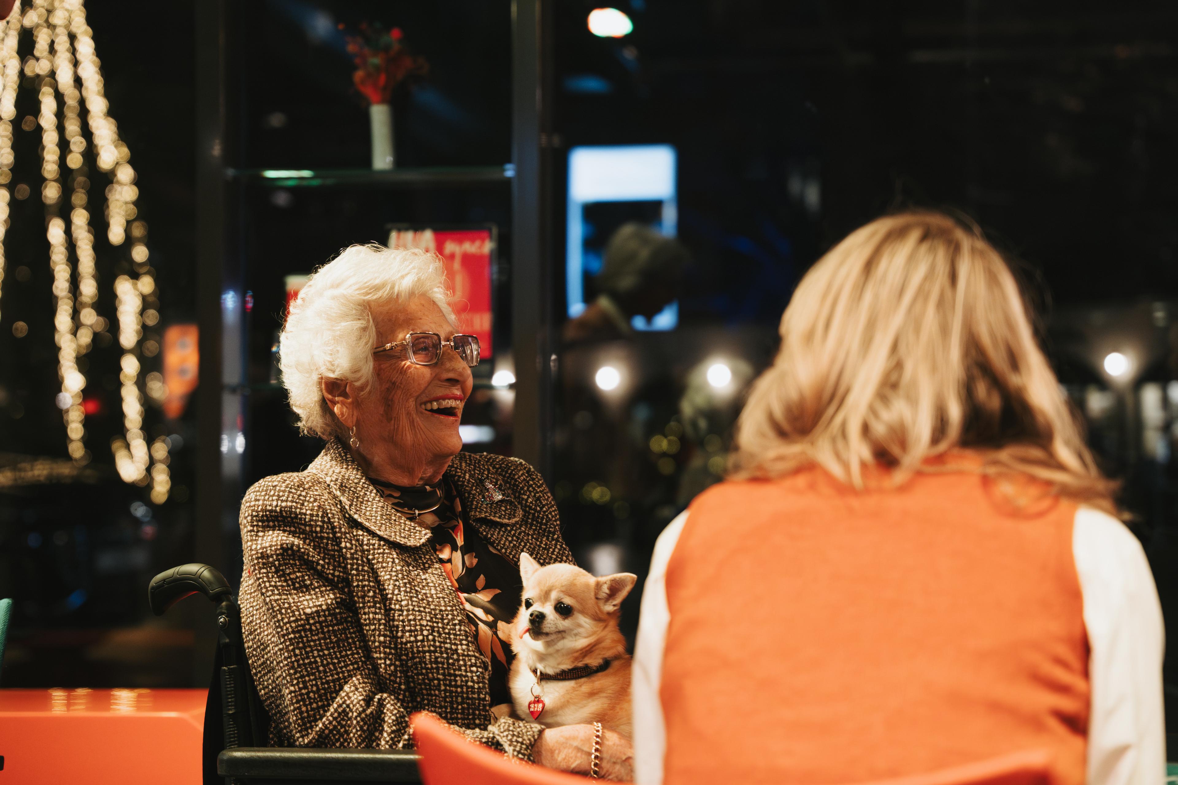 Prinsesse Astrid ler hjarteleg, med hunden på fanget.