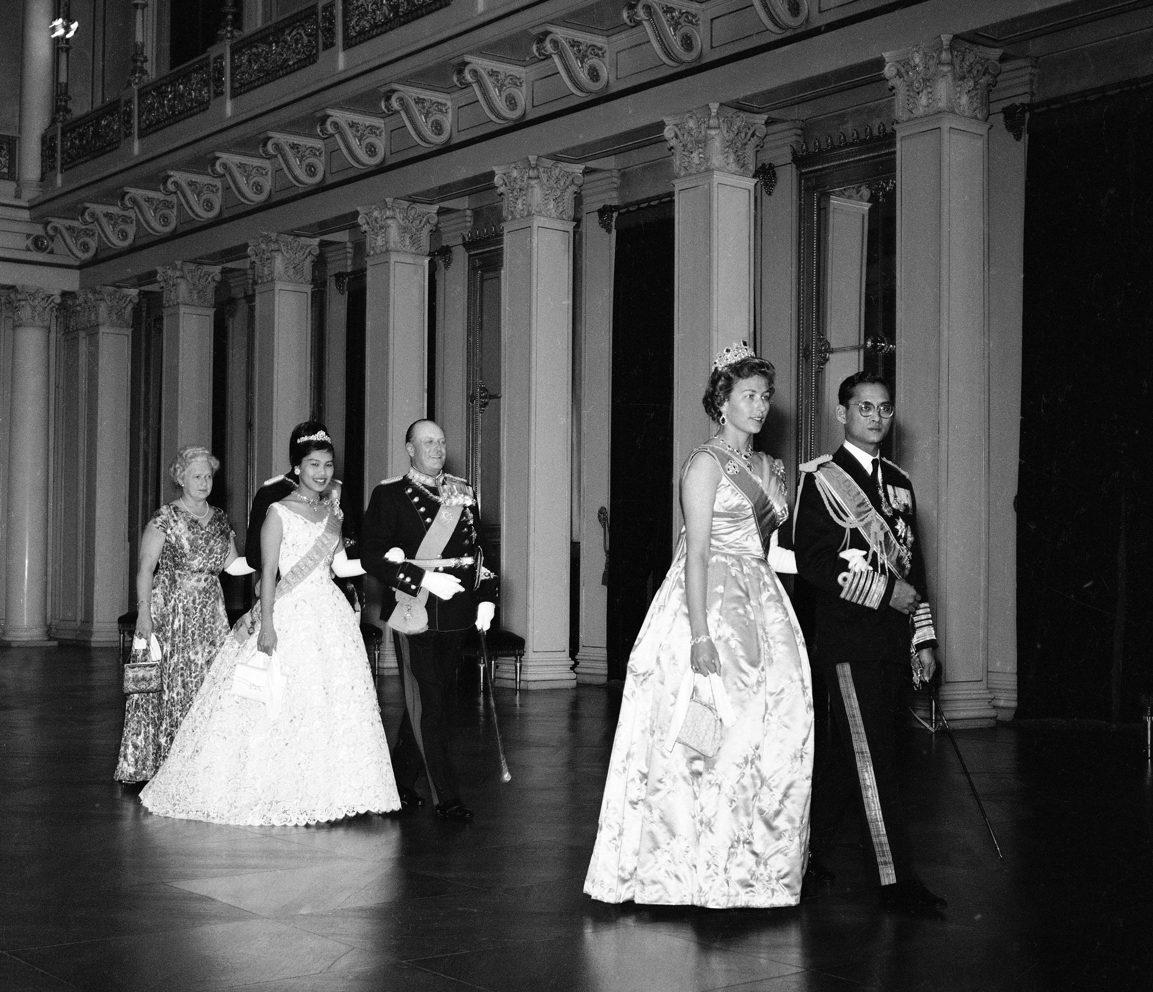 Sorthvitt fotografi av gallakledde gjester på vei gjennom Store festsal på vei til middagenen