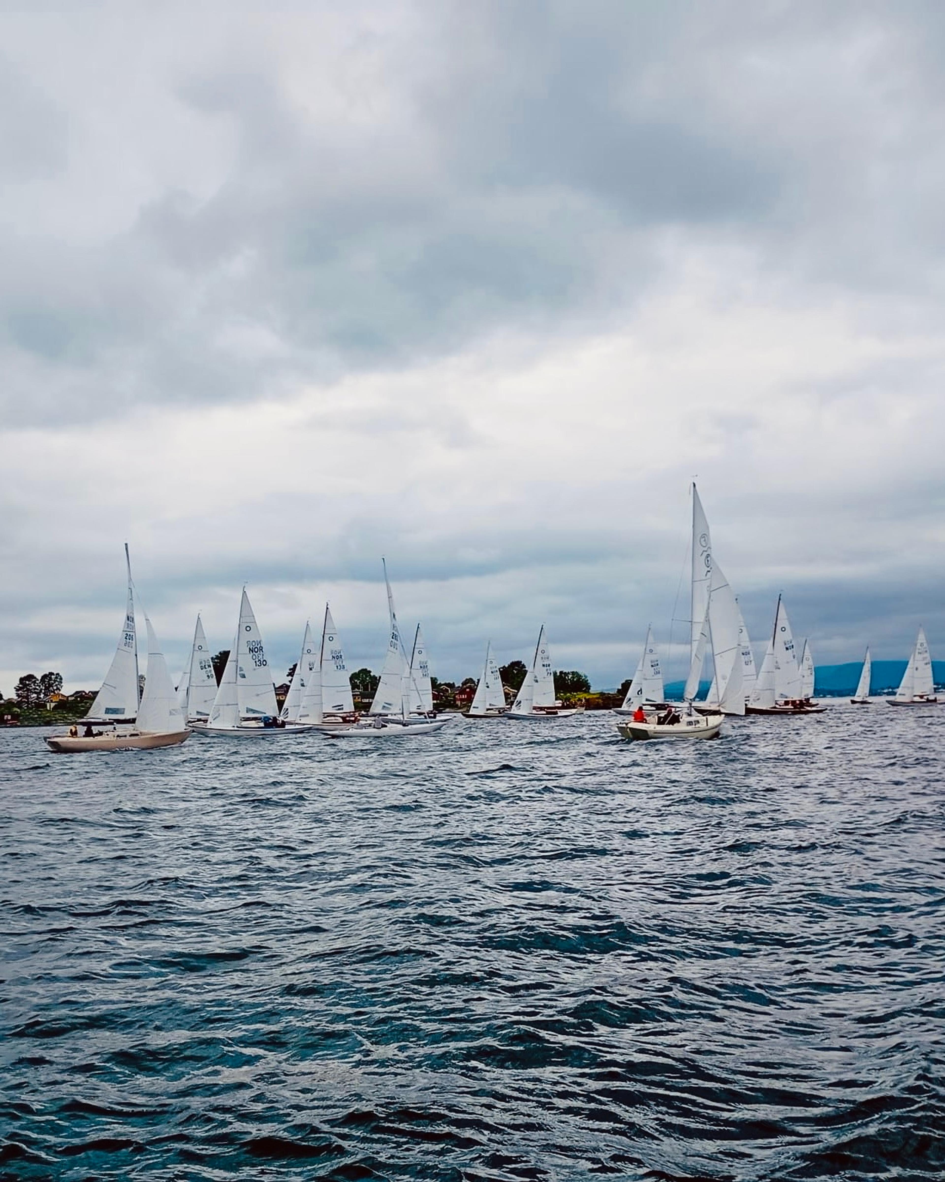 Et titalls med seilbåter på sjøen som deltar i en regatta