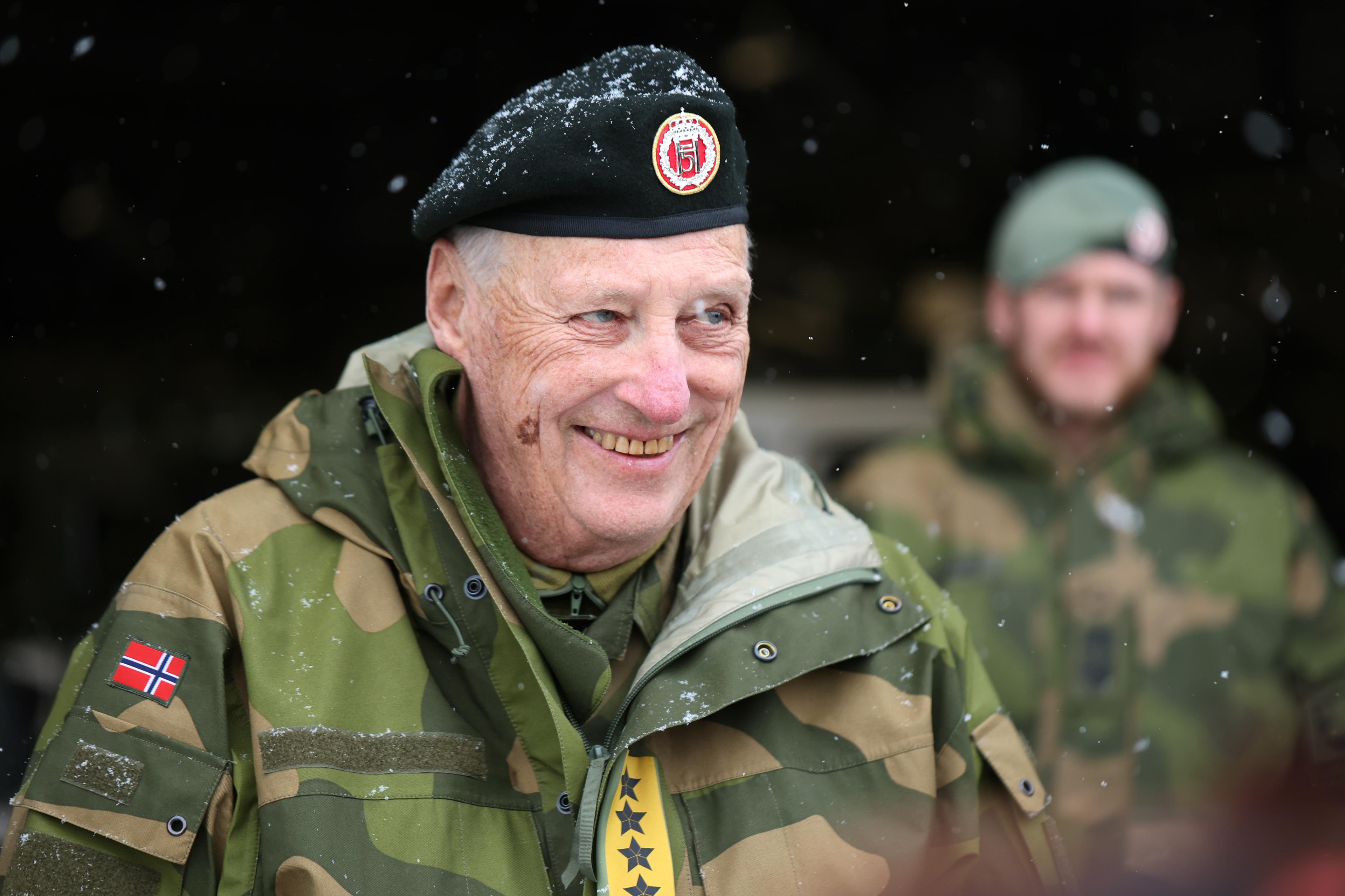 Tett på en smilende Kong Harald i Hærens feltuniform og et merke med fire stjerner.