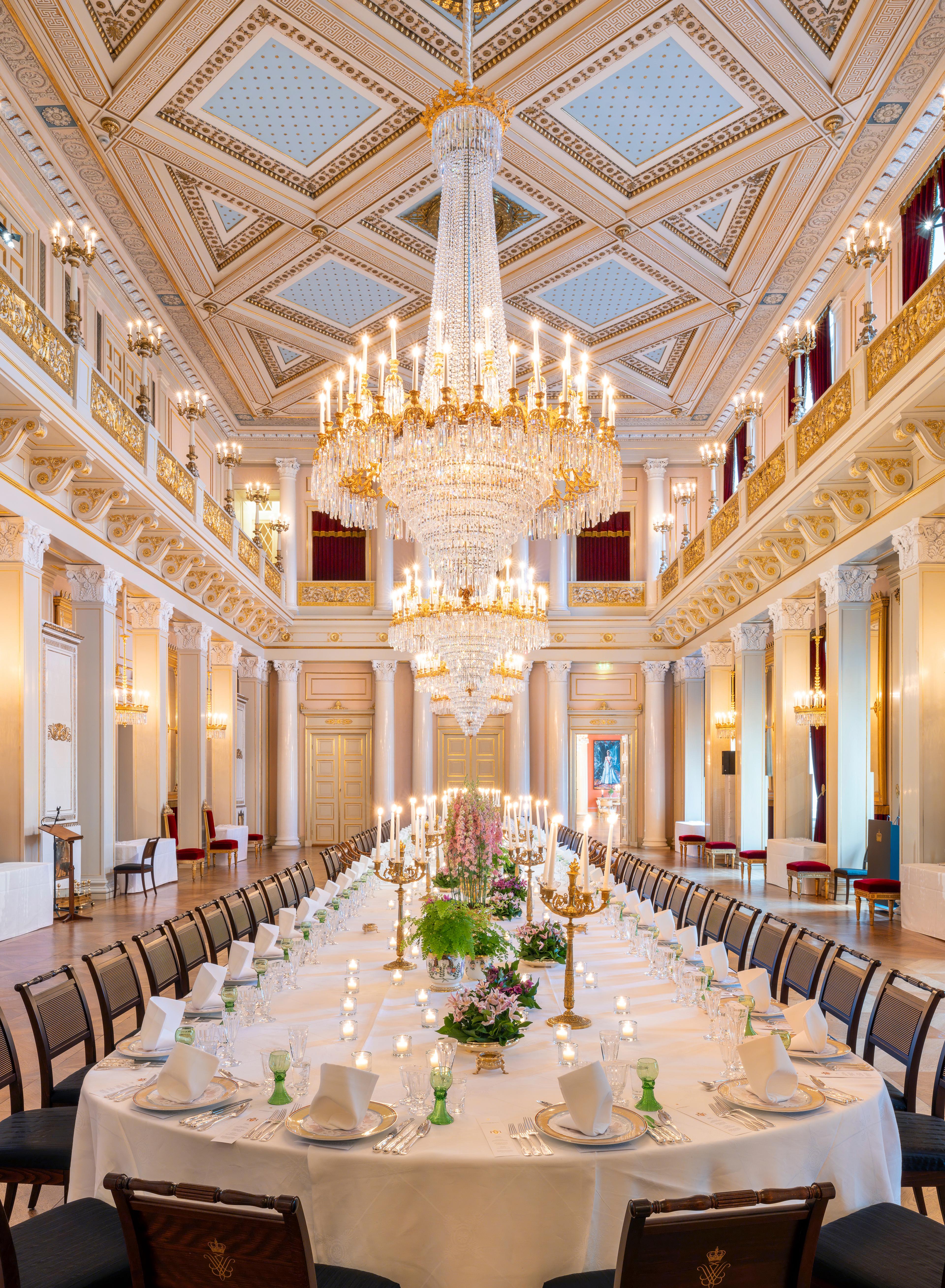 Midt i den store ballsalen står et avlangt bord dekket på til 72 personer.