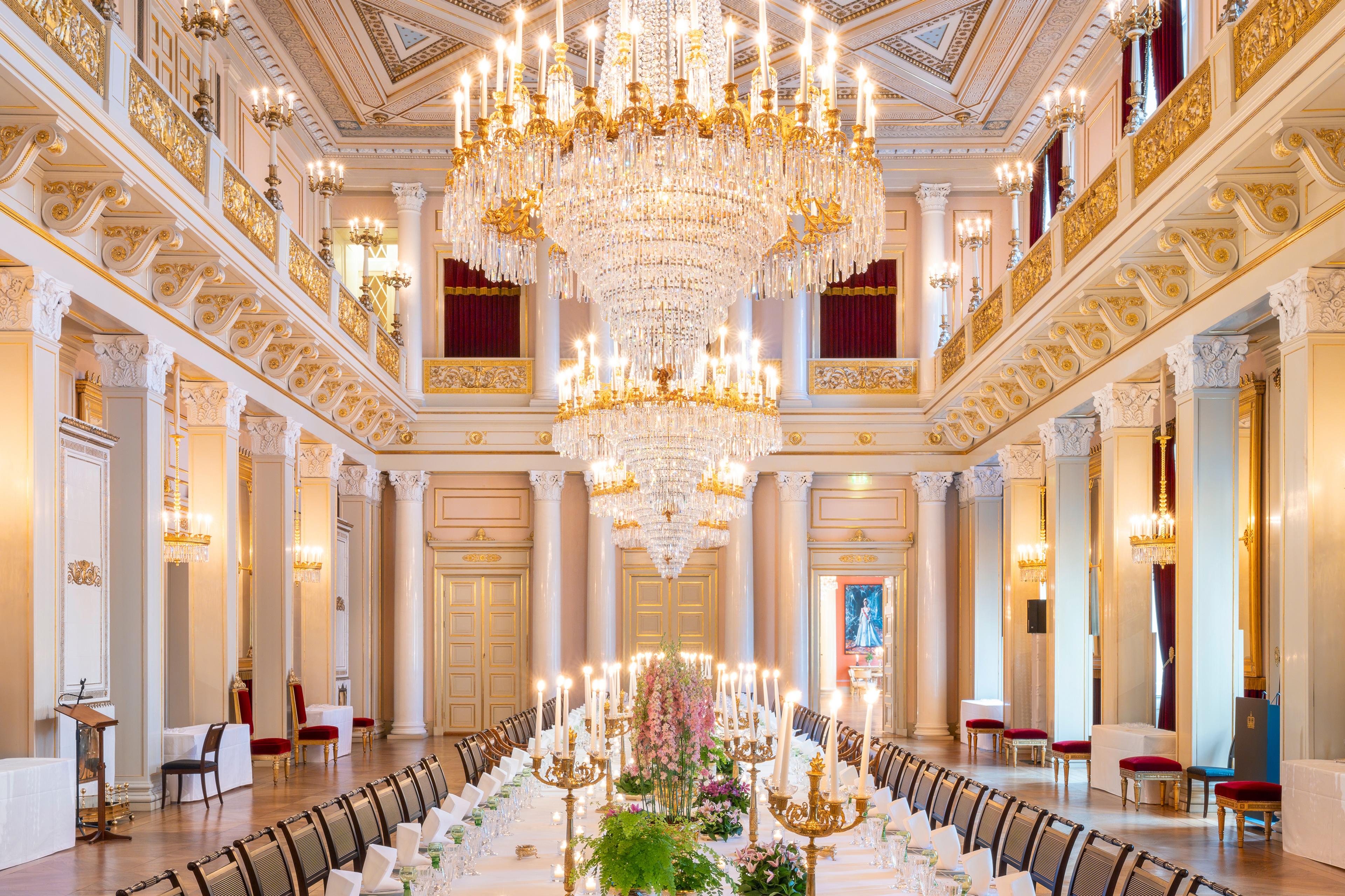 Midt i den store ballsalen står et avlangt bord dekket på til 72 personer.