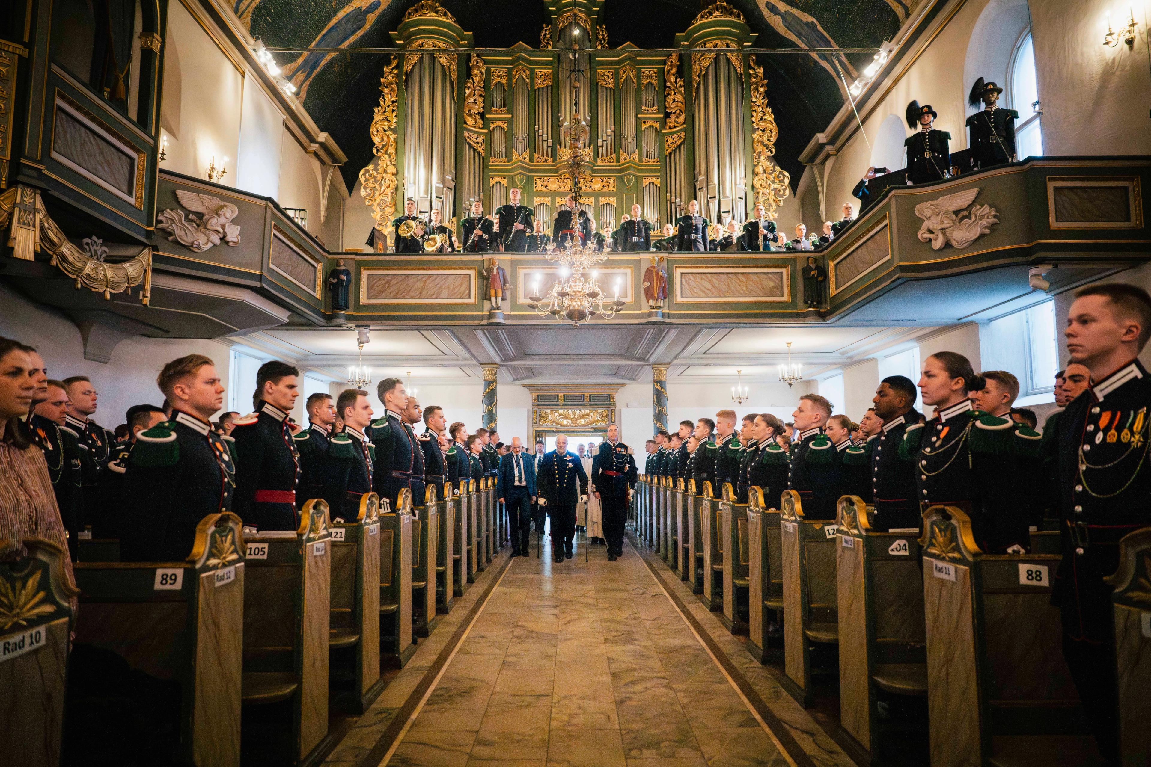Kong Harald går fremst i prosesjon sammen med gardesjef Henrik Hove. Langs sidene står garden oppstilt.