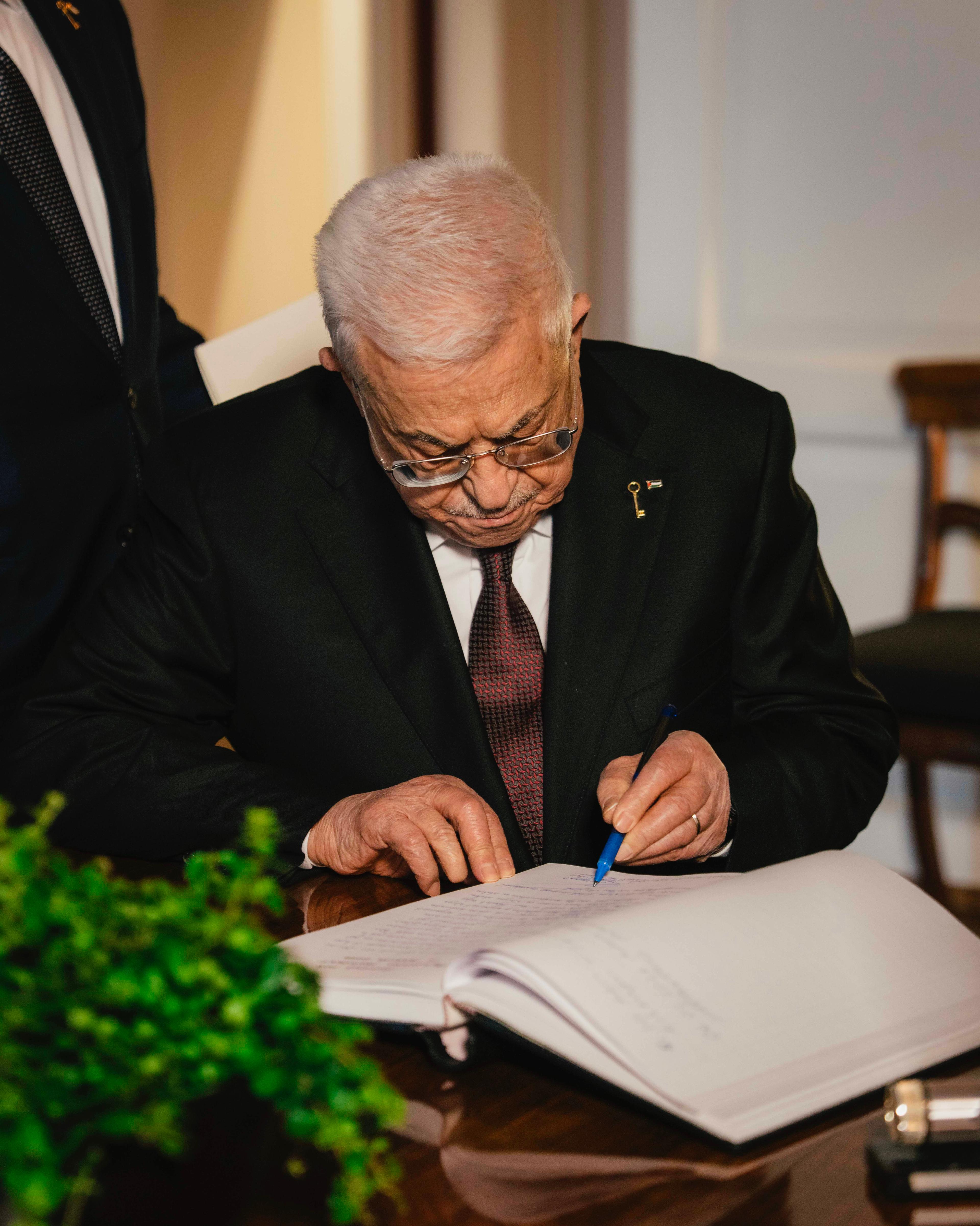 Presidenten sitter ved et skrivebord og signerer.