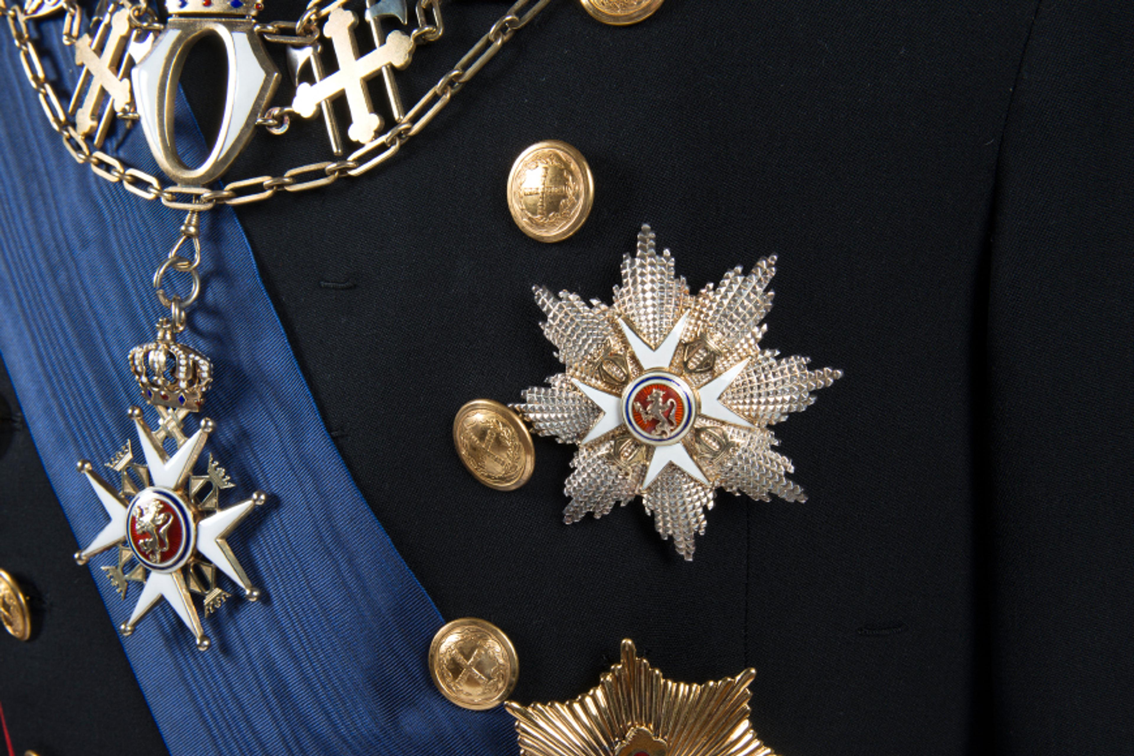 Nærbilde av jakken til Kong Haralds gallauninform med kjedet til St. Olavs Orden og krasjanen fra både St. Olavs Orden og Fortjenstordenen.