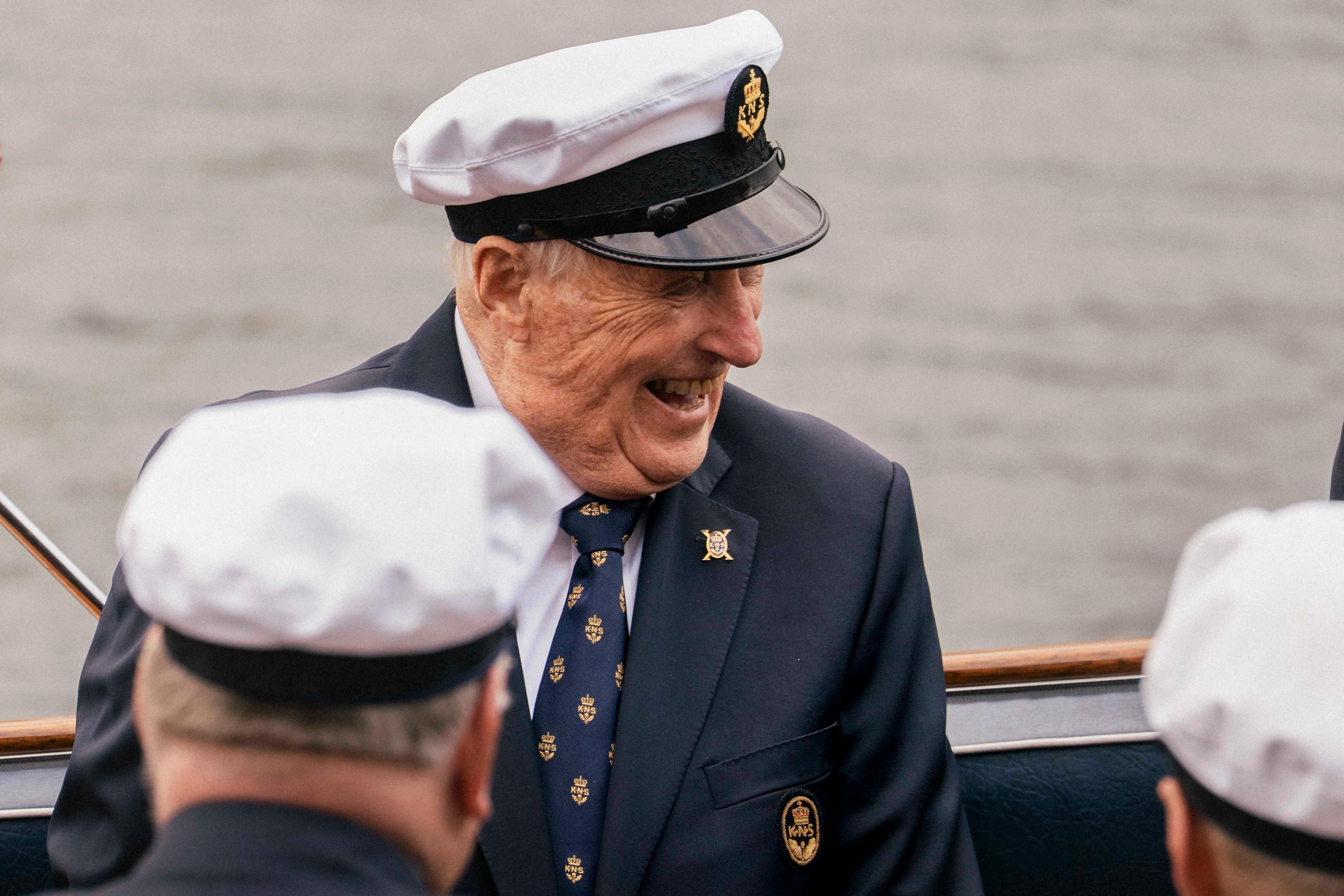 Kong Harlad sitter i Kongebåten Stjernen med et stort smil