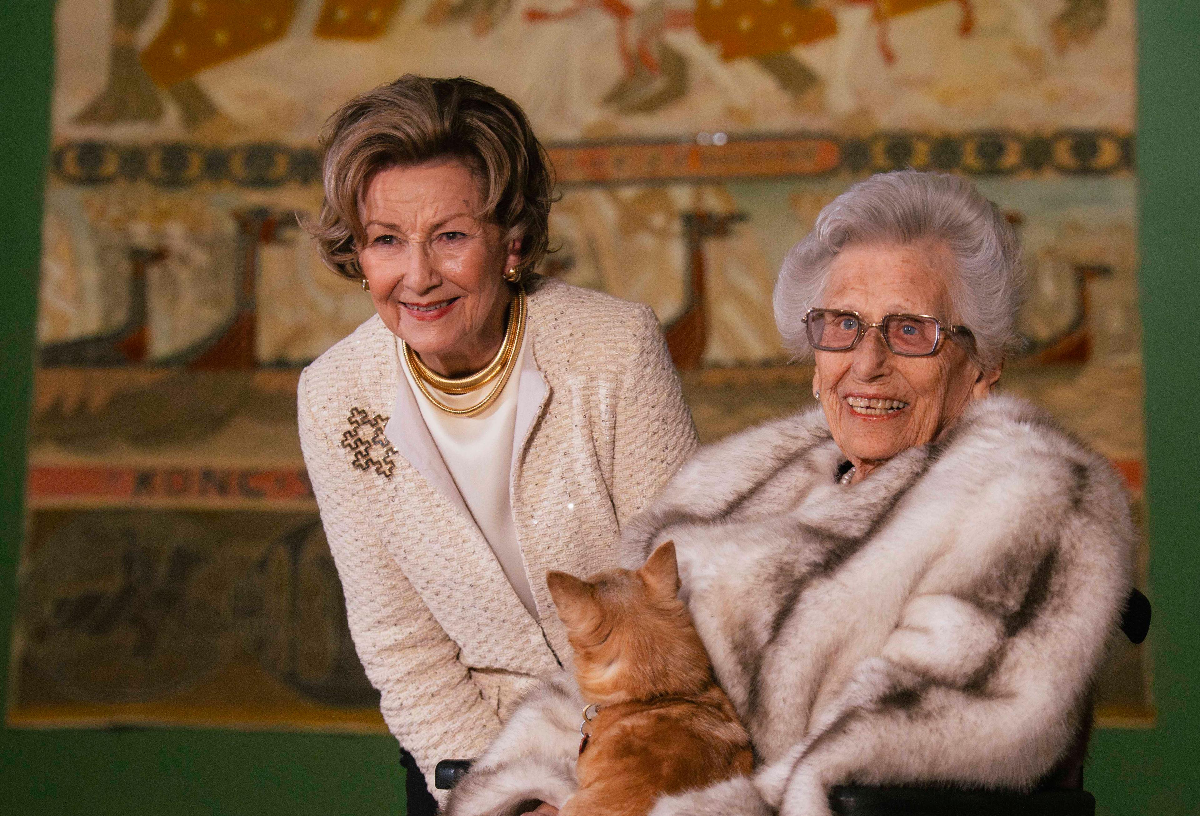 Dronning Sonja og Prinsesse Astrid med et av Riksteppene i bakgrunnen.