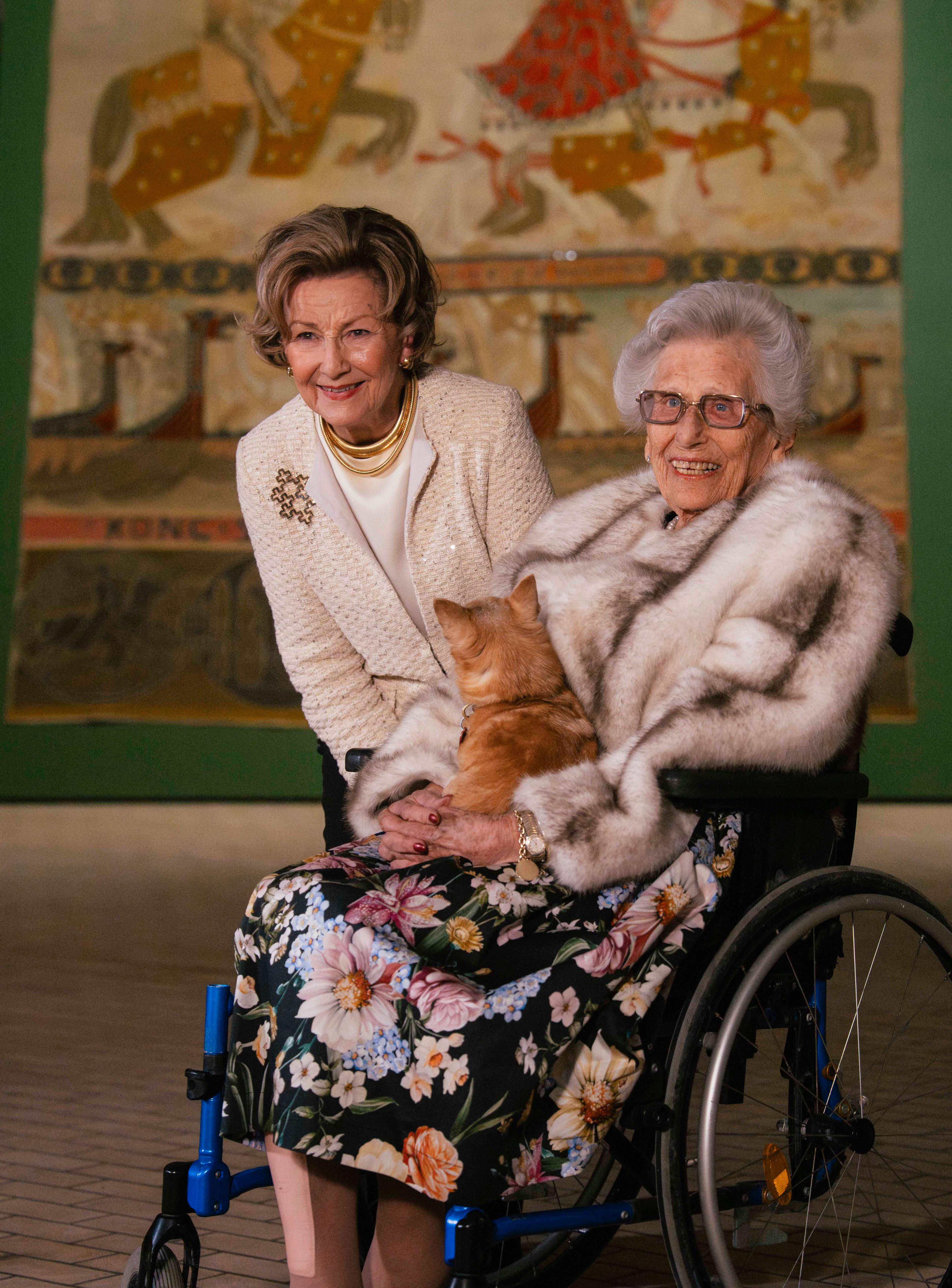 Dronning Sonja og Prinsesse Astrid med et av Riksteppene i bakgrunnen.