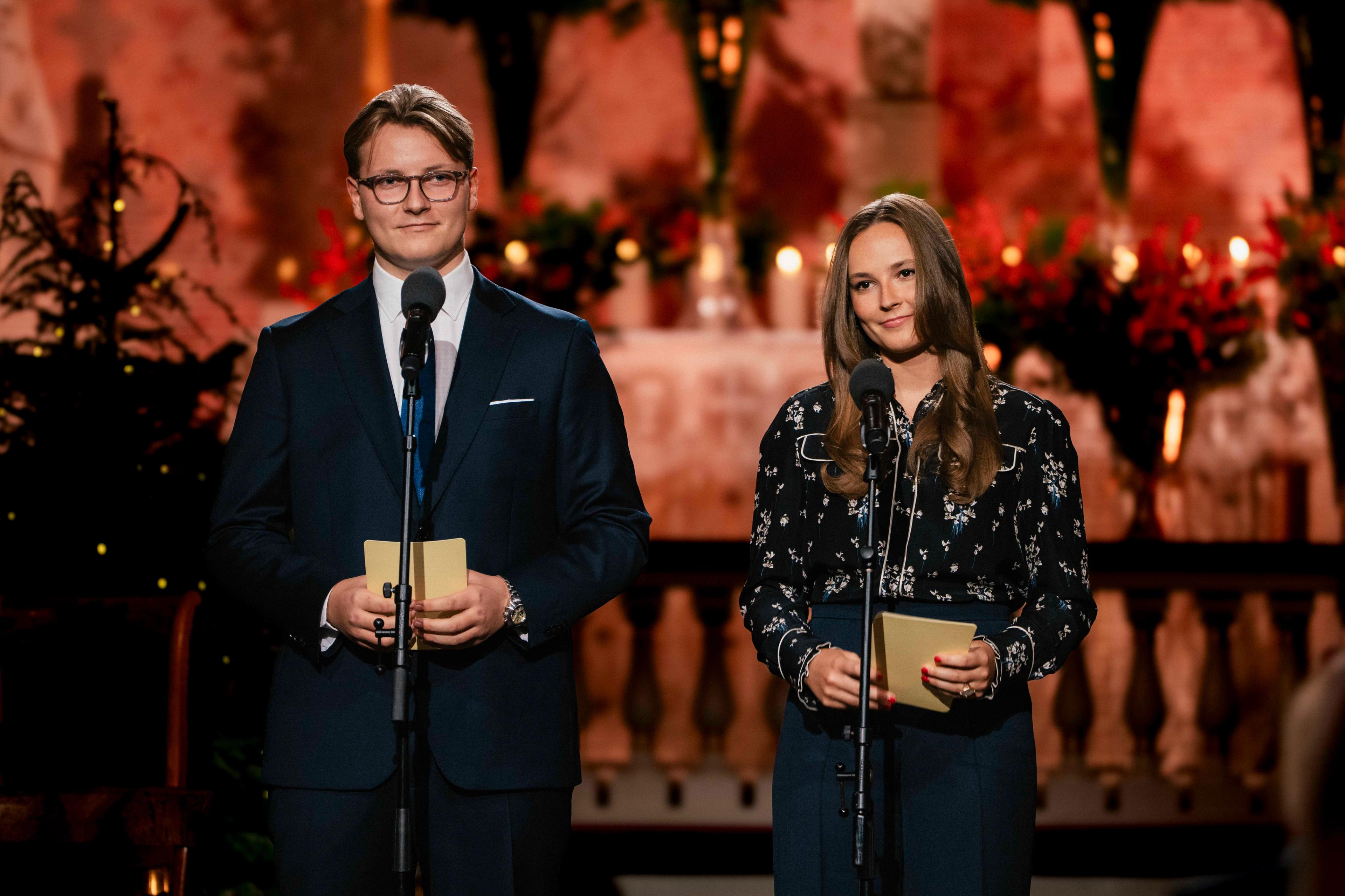 Prinsesse Ingrid Alexandra og Prins Sverre Magnus står vendt mot publikum forman et julepyntet alter i Slottskapellet.