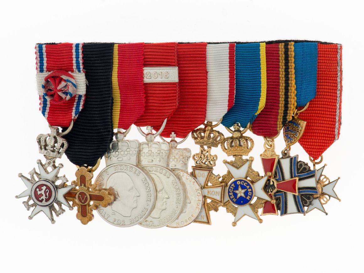 Et titalls ulike medaljer montert i spenne - St. Olavs Orden fremst.