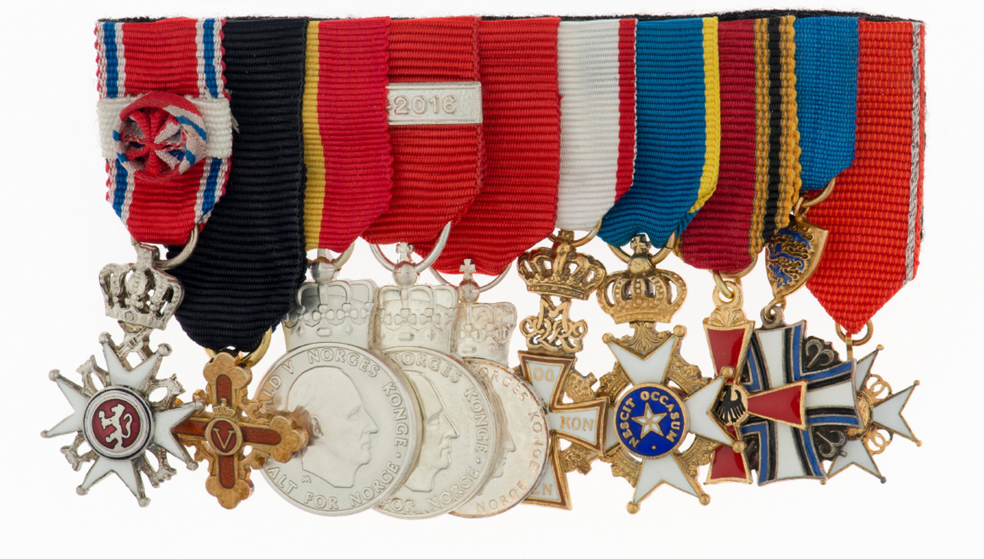 Et titalls ulike medaljer montert i spenne - St. Olavs Orden fremst.